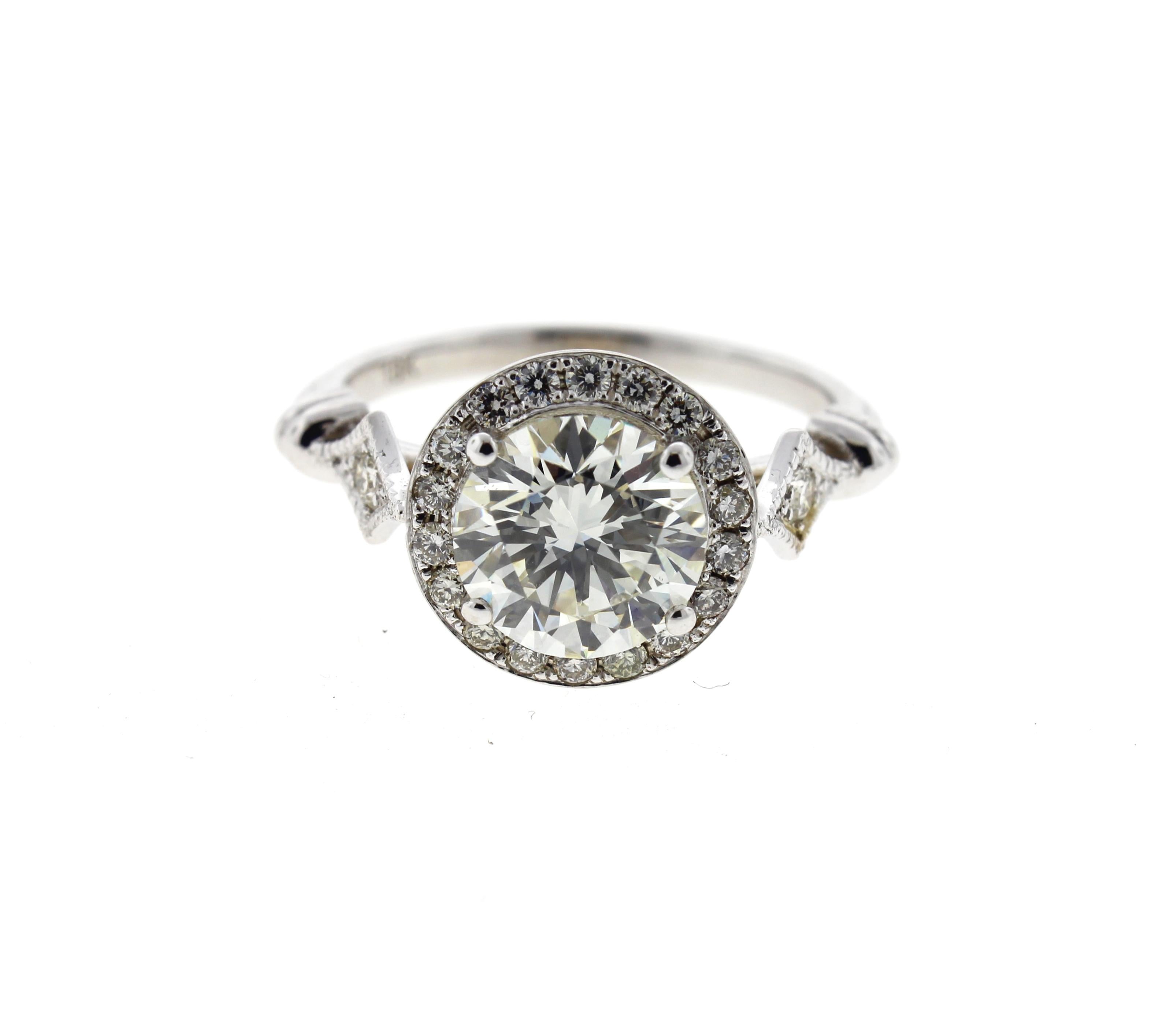 This Edwardian style diamond engagement ring is crafted in 14k white gold, and contains a Round Brilliant Cut Diamond (0.61 carat, F Color, SI1 Clarity) and is surrounded by 28 Round Brilliant Cut diamonds (0.14 total carat weight, F Color, SI