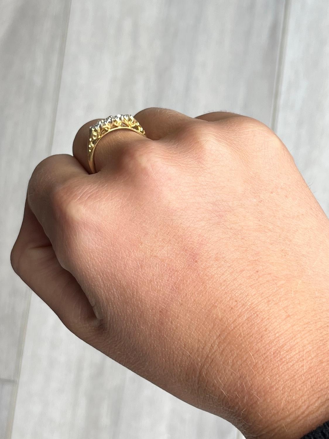 Five glistening diamonds sit fabulously on top of a simple open work setting modelled in 18ct gold. The old mine cut diamonds total 50pts. 

Ring Size: M or 6 1/4 
Width: 4mm
Height Off Finger: 4mm

Weight: 2.68g