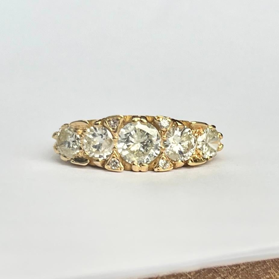 Five glistening diamonds sit fabulously within a simple setting modelled in 18ct gold. The central stone measures 65pts, the next size measure 35pts each and the smallest stones measure 15pts each. Either side of the largest stone are pairs of