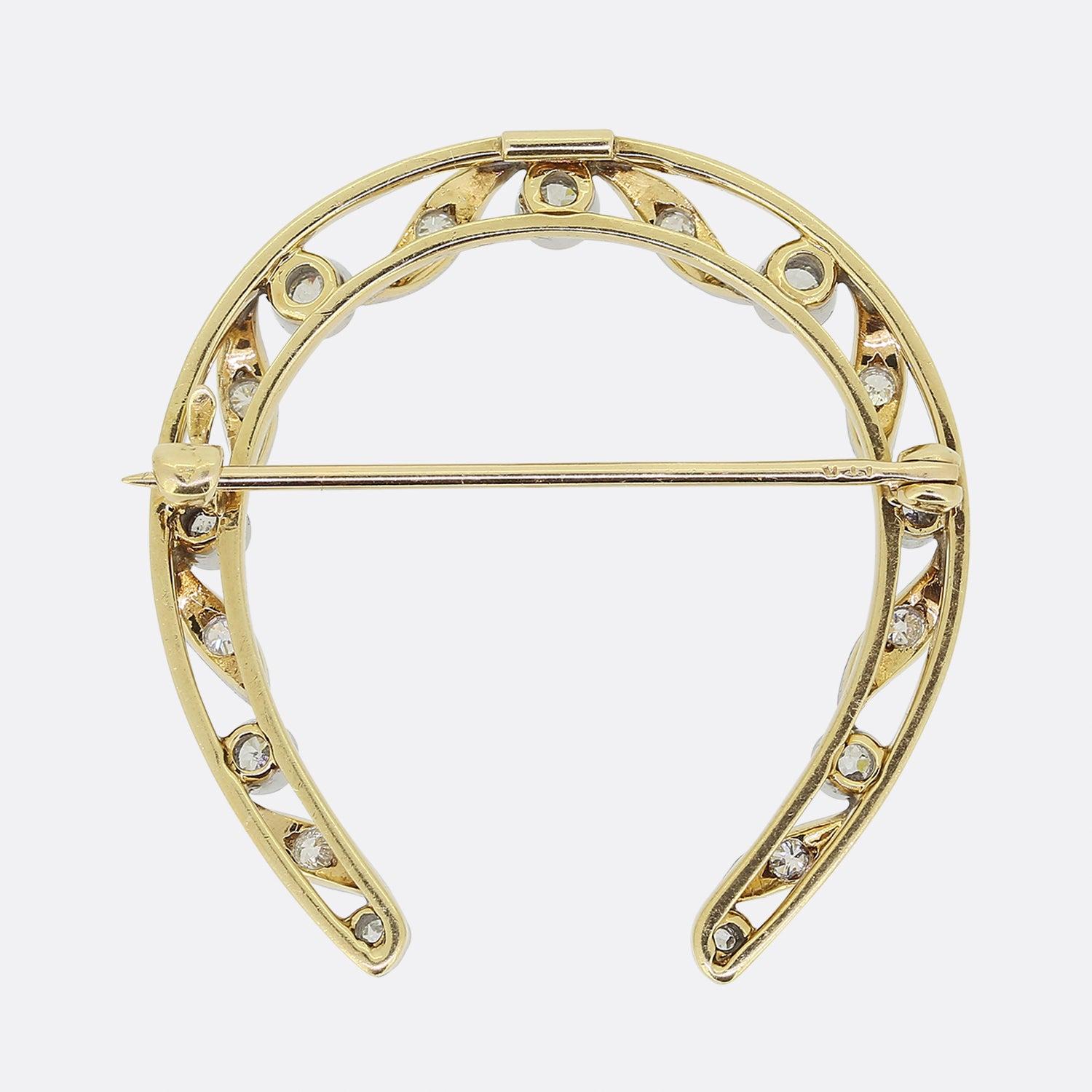 Here we have a lovely diamond brooch dating back to the Edwardian period. This antique piece has been crafted from 18ct yellow gold into the shape of a horseshoe. The main open frame plays host to an array of individually milgrain set round faceted