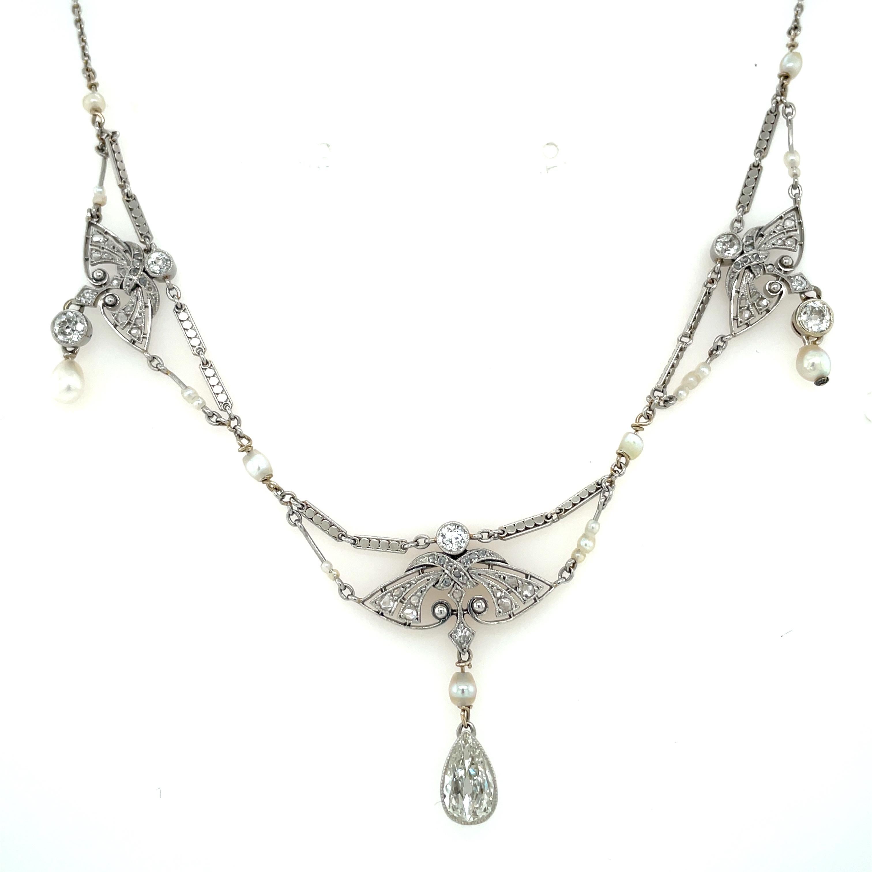 Genuine antique 1900's Edwardian platinum necklace featuring one large Pear European cut, 0,80 ct I-K color Vs2 clarity, Natural pearls and single-cut diamonds.

This jewel is authentic in every part, the engraving and filigree make it unique. 
The