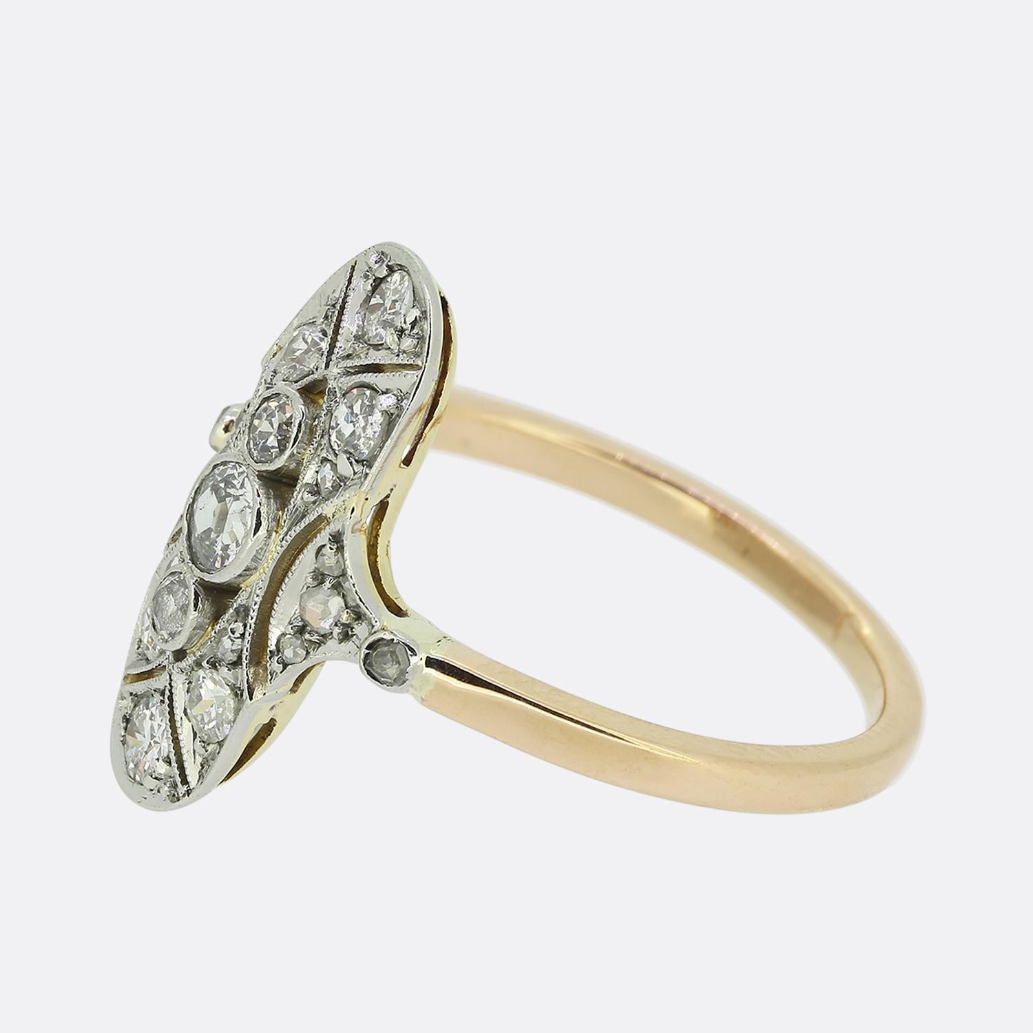 Here we have a delightful diamond navette ring dating back to the Edwardian period. At the centre of the face we find three round faceted old European cut diamonds in a vertical formation. This trio sits slightly risen atop a platinum pierced open