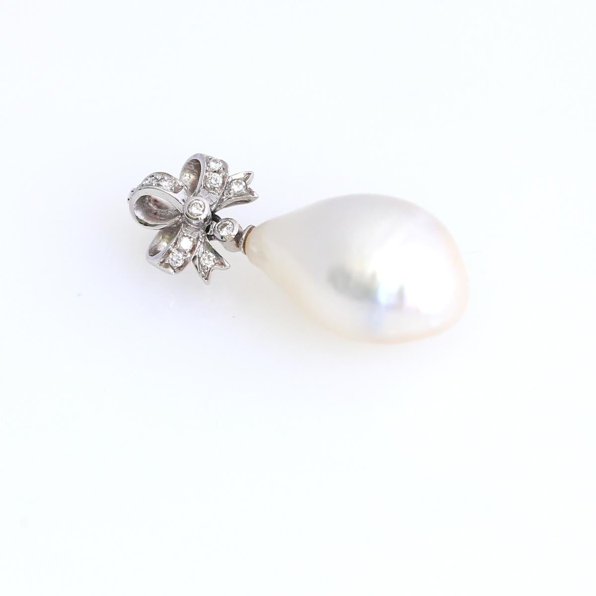 The white/silver pearl hang from charming platinum and gold diamond box ribbon motif pendant. 1910. Lock stamped 18K.
Very comfortable lock, which can be mounted on a Pearl necklace or on its own. Pearl is probably the most ancient jewelry item. It