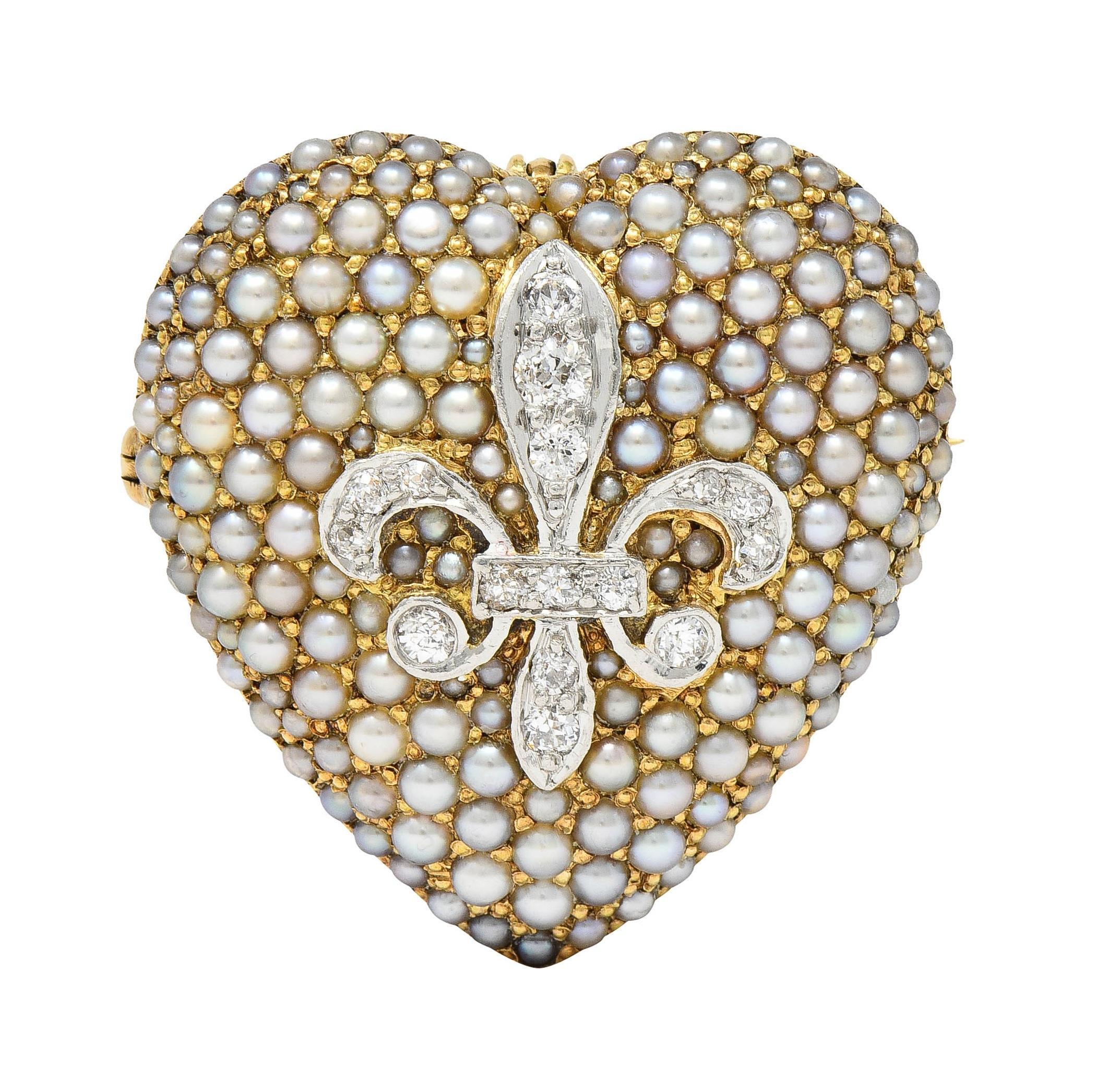 Designed as a domed heart shaped form centering a platinum-topped fleur-de-lis motif
Bead set with old European cut diamonds weighing approximately 0.72 carat total
H to J color with VS2 clarity - heart surround is pavé set with seed pearls 
Ranging
