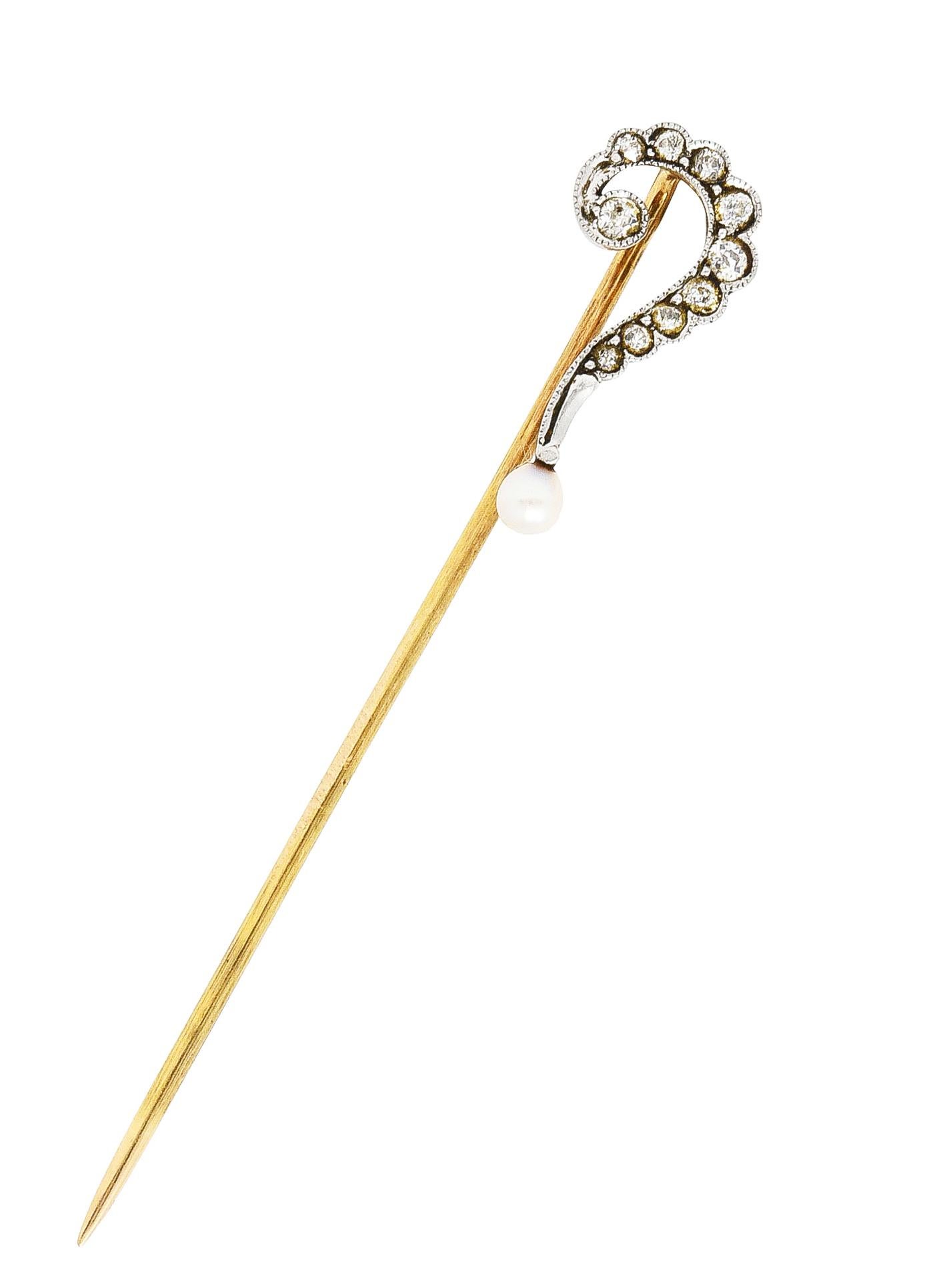 Depicting a whiplash question mark with milgrain edges. Featuring old European cut diamonds bead set throughout. Weighing approximately 0.25 carat total - quality consistent with age. Accented by a pearl at the tail end of the symbol. Pearl is 3.0