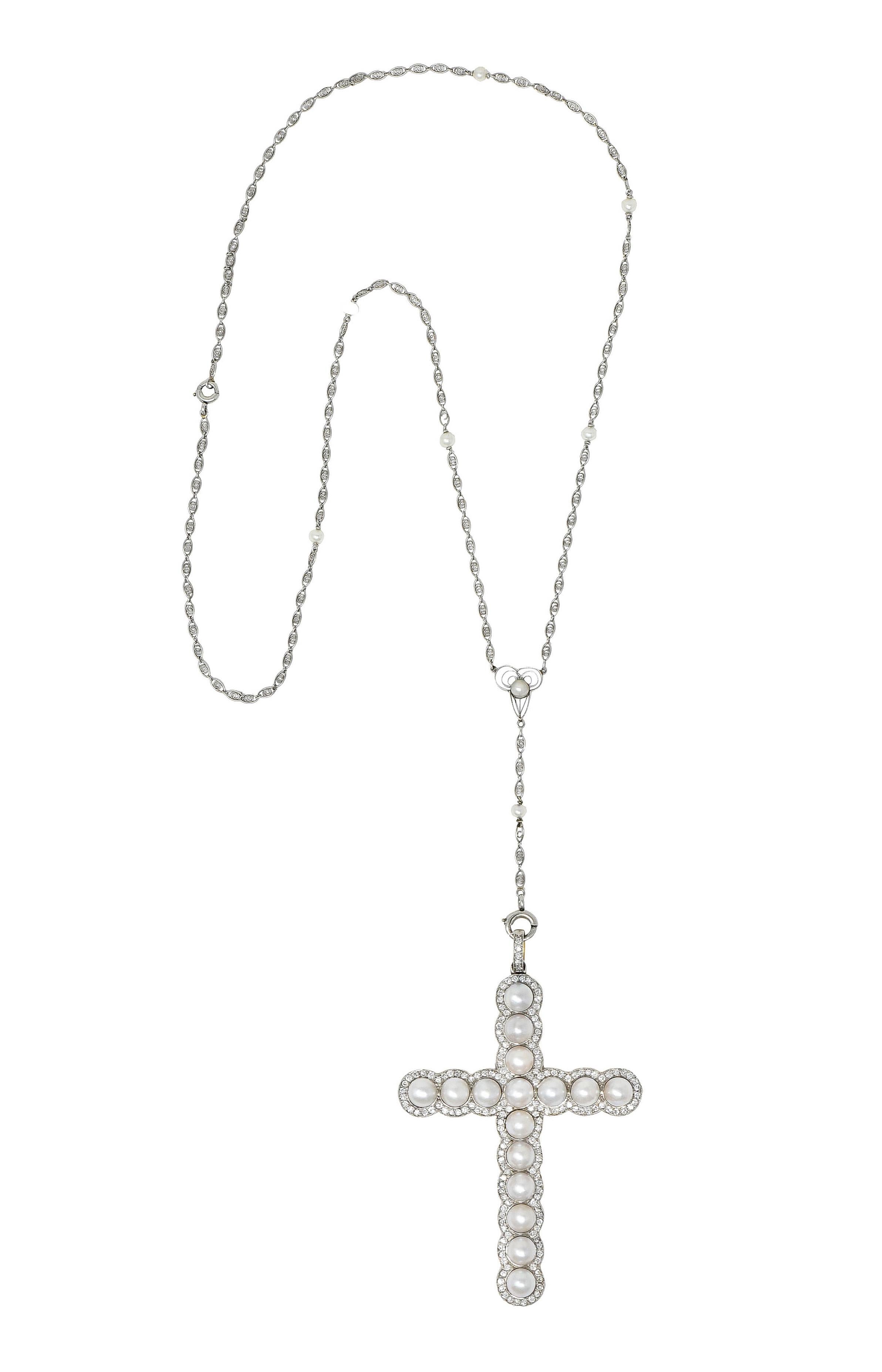 Chain necklace is comprised of spiraled eyelet links interspersed with 3.5 mm pearl stations

Terminating as a trefoil center station with a C clasp drop that suspends a substantial cross pendant

Cross features 6.0 mm button pearls - cream in color