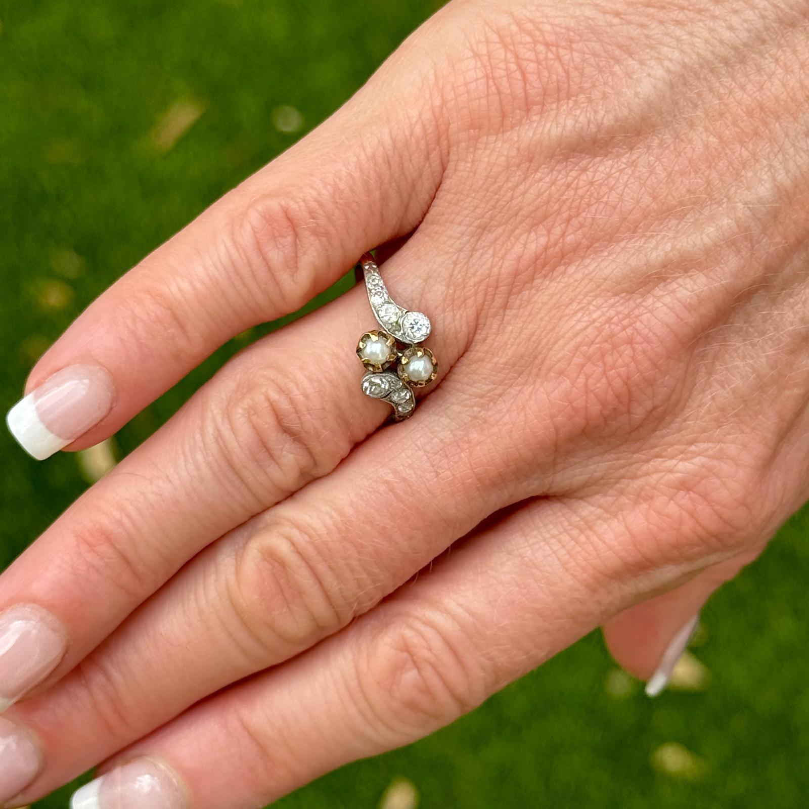 This Edwardian diamond and pearl ring is a splendid representation of the romantic and elegant jewelry of the early 20th century. The ring features a delicate and intricate design that showcases the opulence and sophistication of the Edwardian era