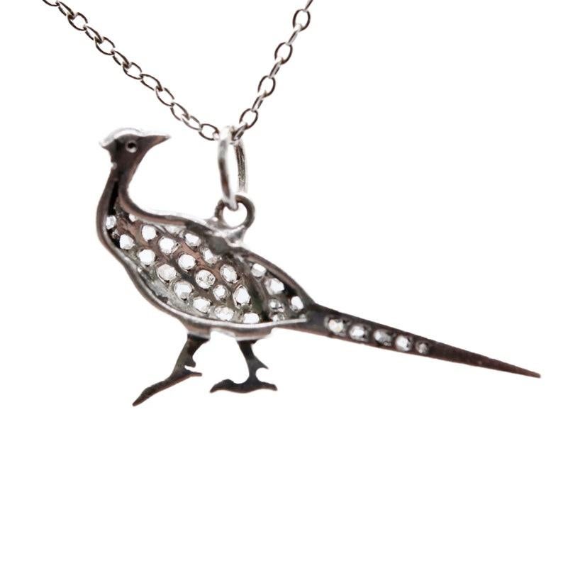 Aston Estate Jewelry Presents:

An edwardian period diamond set pheasant bird pendant in platinum. Pave set throughout with 36 diamonds of 0.40ctw. Crafted with exceptional detail, down to the carved beak, and diamond set eye.

Tests as