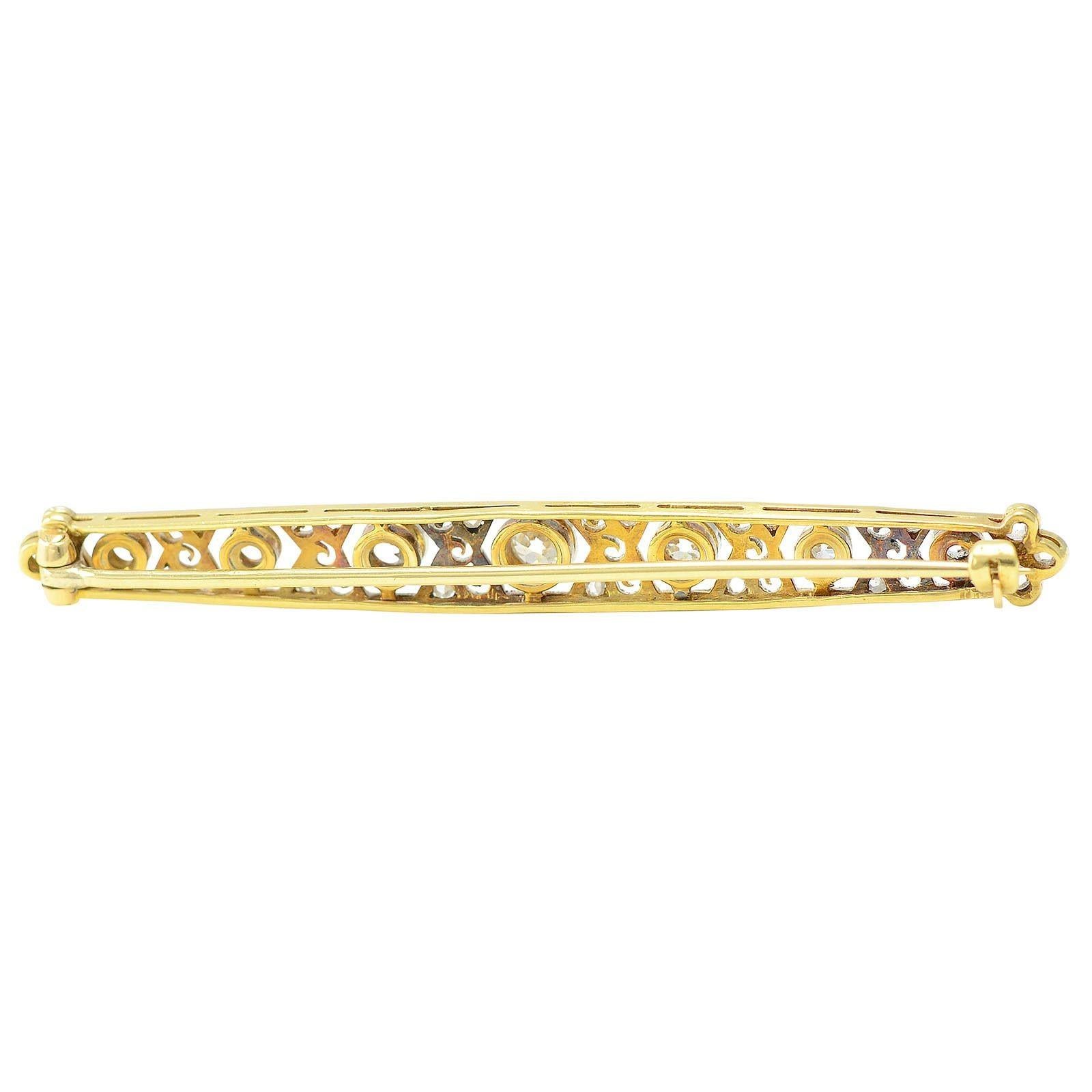 Antique Edwardian diamond pin, circa 1910. This antique pin is crafted in platinum and 18 karat yellow gold. The Edwardian pin features seven old European cut diamonds at .67 carat total weight with VS-SI clarity and H-J color. There are also 18