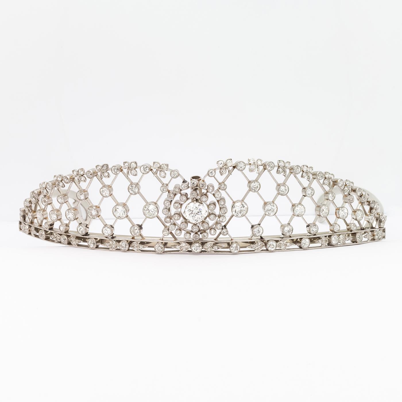 An antique diamond tiara, set with old-cut diamonds, with a two row diamond cluster, with a suspended diamond in the centre and a suspended pear shape diamond above, flanked by lattice work, with diamonds set at the intersections, in millegrain