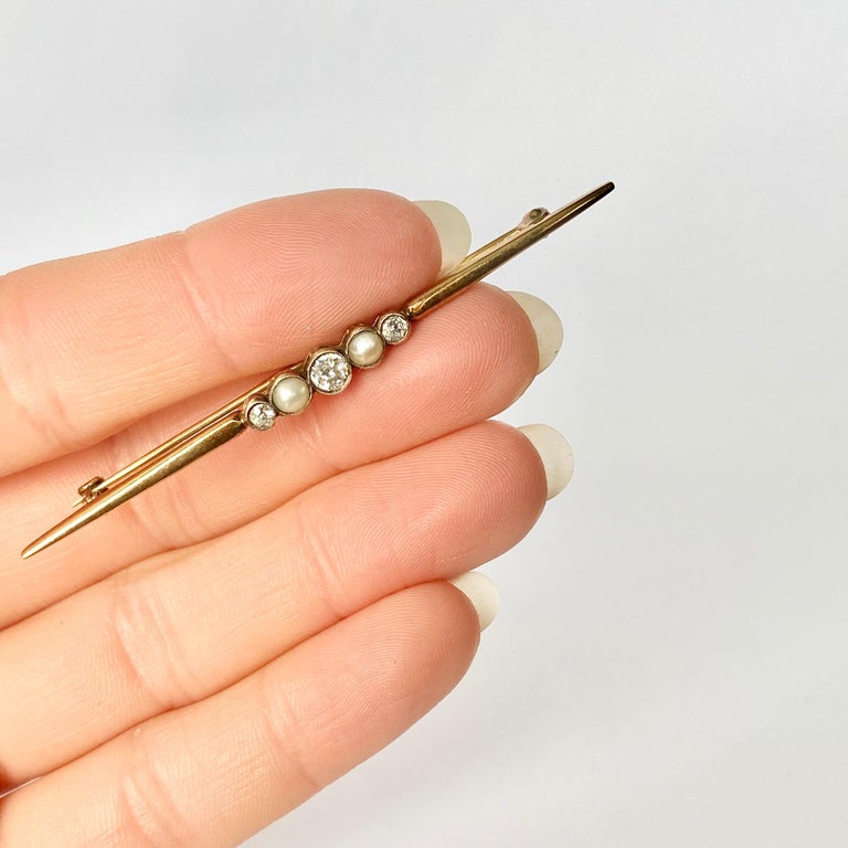 This gorgeous pin is modelled in 9 carat gold and has a simple and classic design. The three  diamonds measure 30pts and in between these bright stones are pearls. 

Length: 66mm

Weight: 3.4g