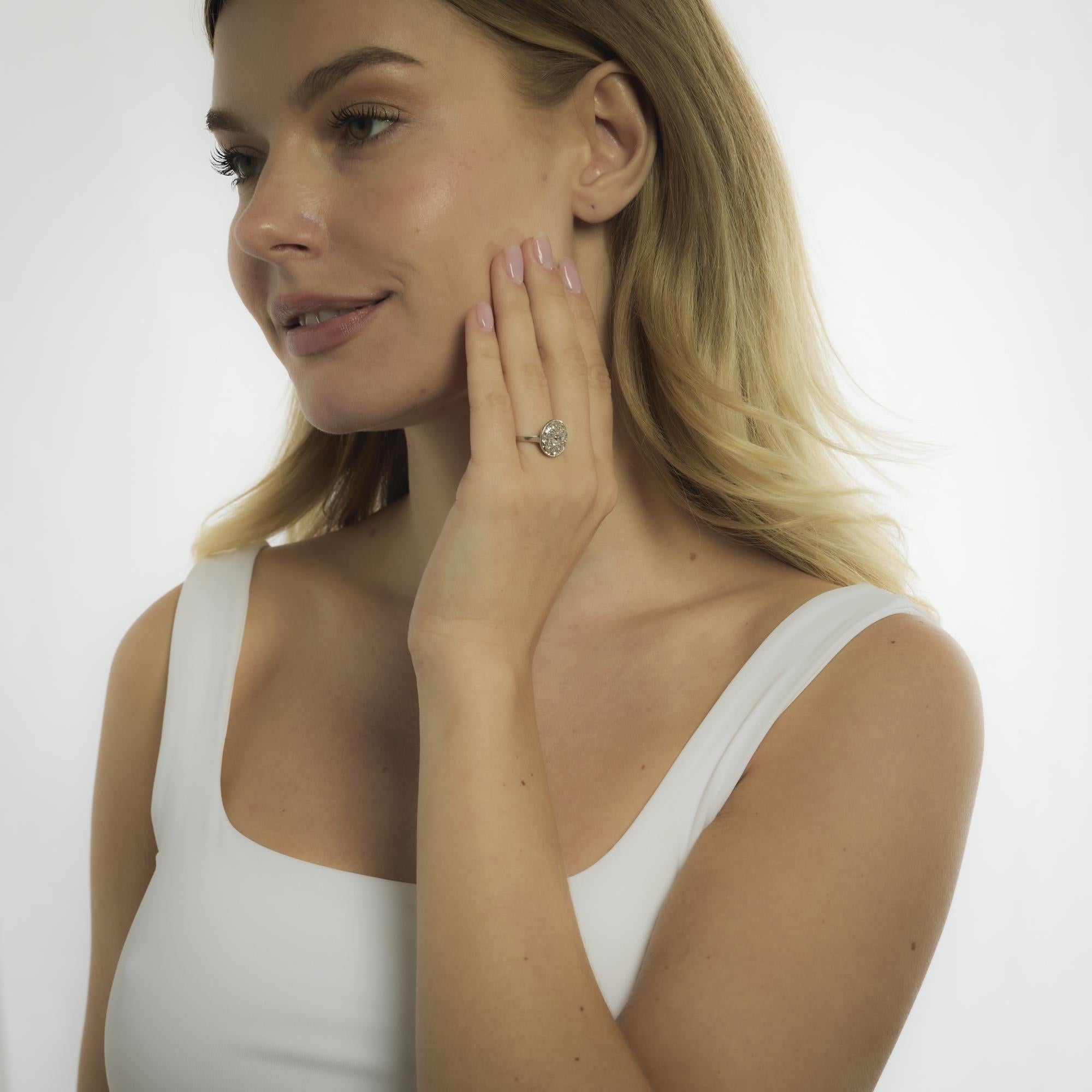 An Edwardian platinum ring from 1915, centering a glowing old mine cut diamond framed by additional mine cuts, radiating antique elegance and refined vintage charm.