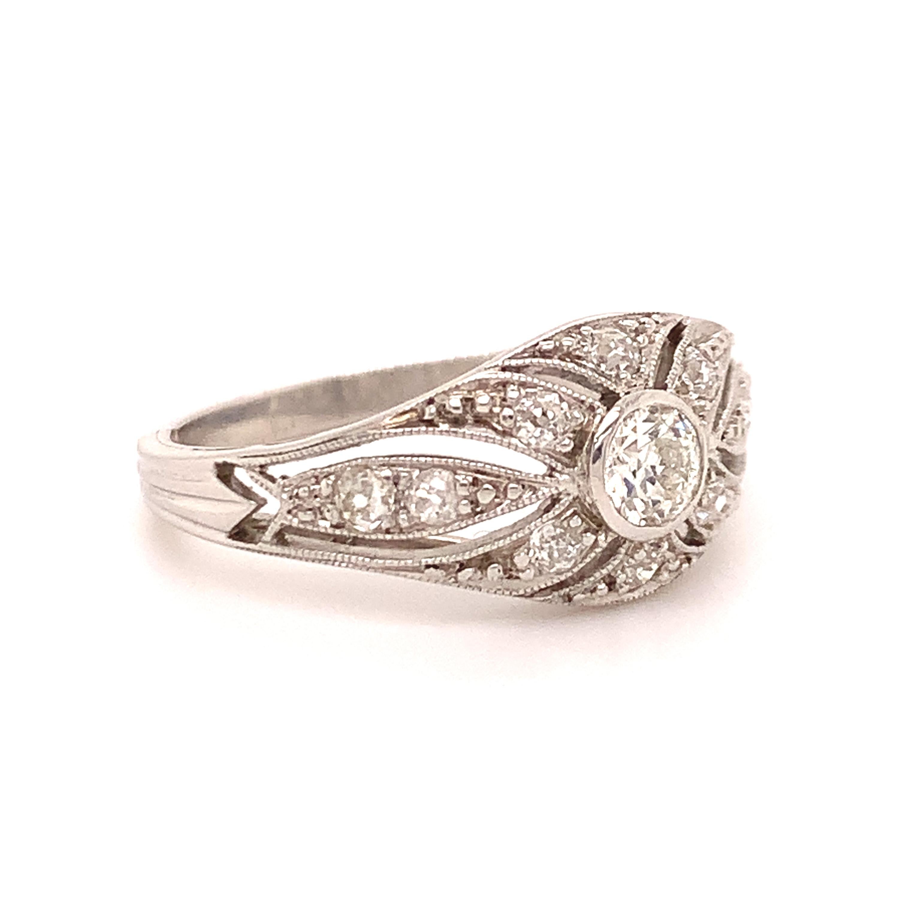 Lovely antique diamond engagement ring, set in platinum.  A softly rounded shape contours the low-set starburst of diamonds, with a shimmering old mine cut in the center.  Openwork gallery and engraved shank.  Approximately 3/4 carat total weight. 