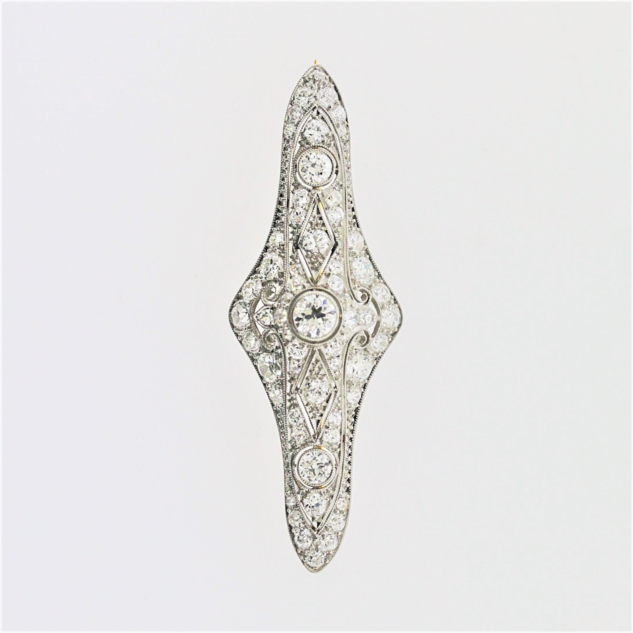 A classic Edwardian piece, circa 1915, featuring 2.55 carats of European-cut diamonds. They are set around the 3-dimensional piece decorated with filigree and garland style motifs typical of the Edwardian era. Made in platinum and finished with a