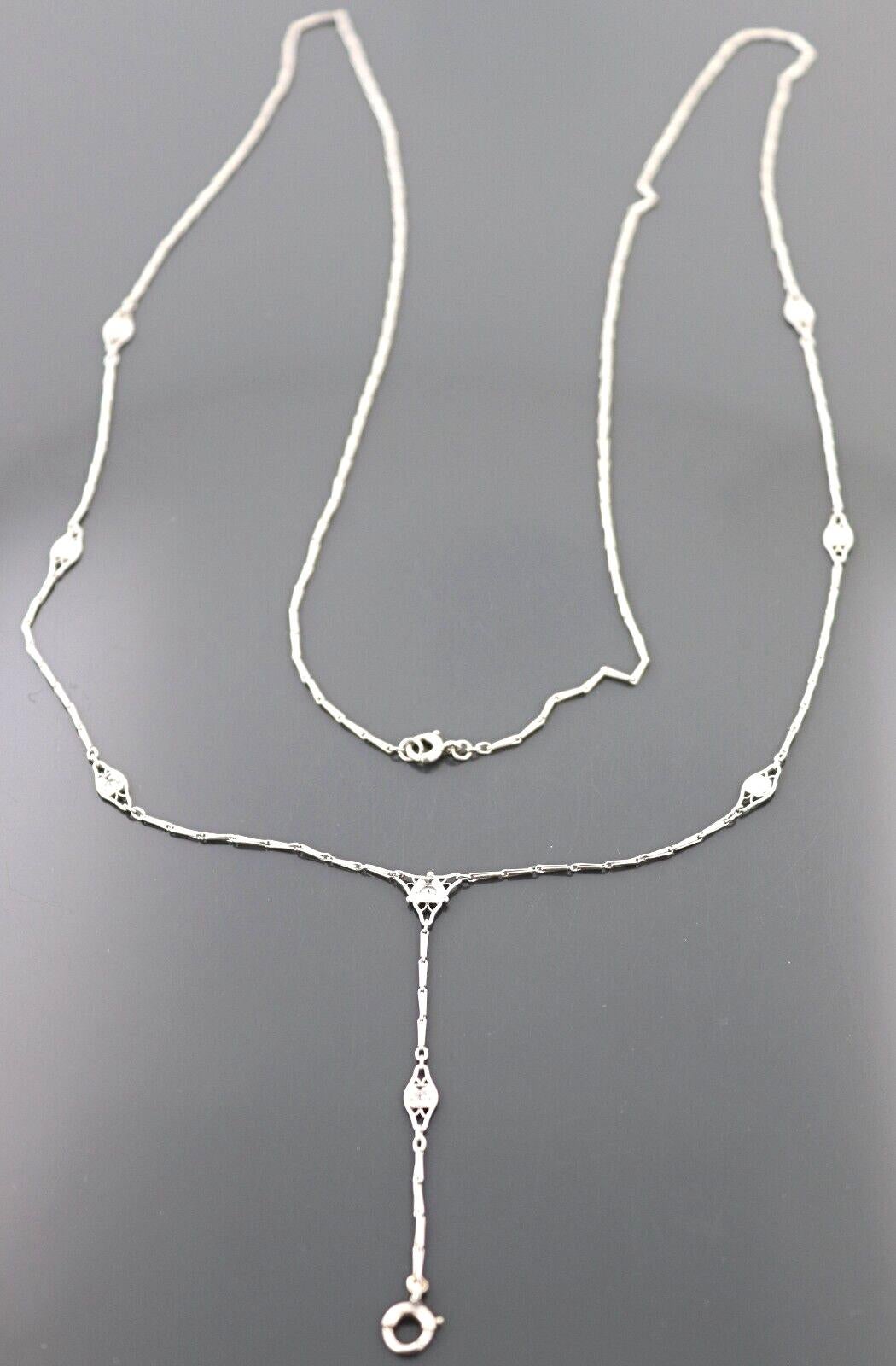 Featuring (8) old European-cut diamonds, 0.40 ct. tw., VS, G-H, each set in a platinum filigree lozenge
shaped links, interspaced by wire bar links, suspending a 2-inch lavalier style link with spring ring clasp,
completed by a platinum spring ring
