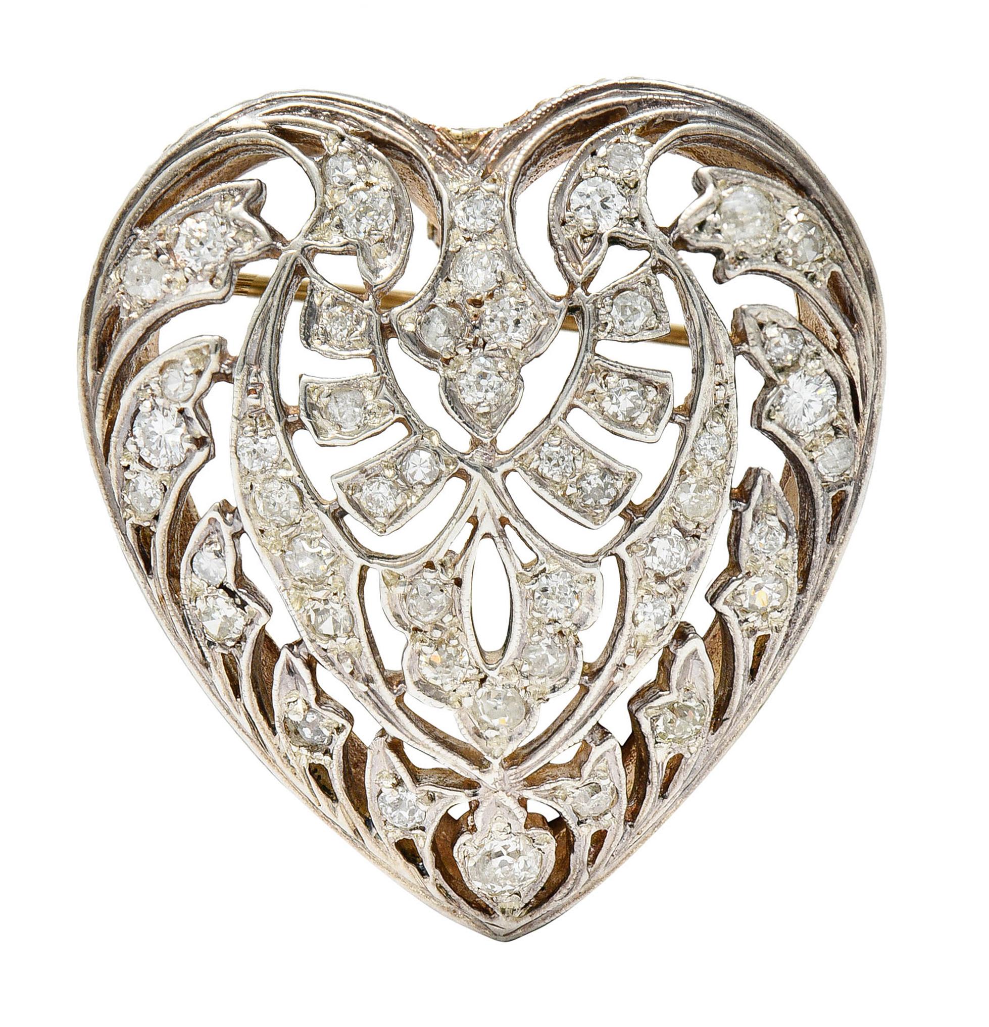 Pendant brooch is designed as a pierced and scrolling heart

Accented throughout by single and old European cut diamonds

Weighing in total approximately 1.35 carats with varied color and clarity - consistent with age

Completed by a pin stem with