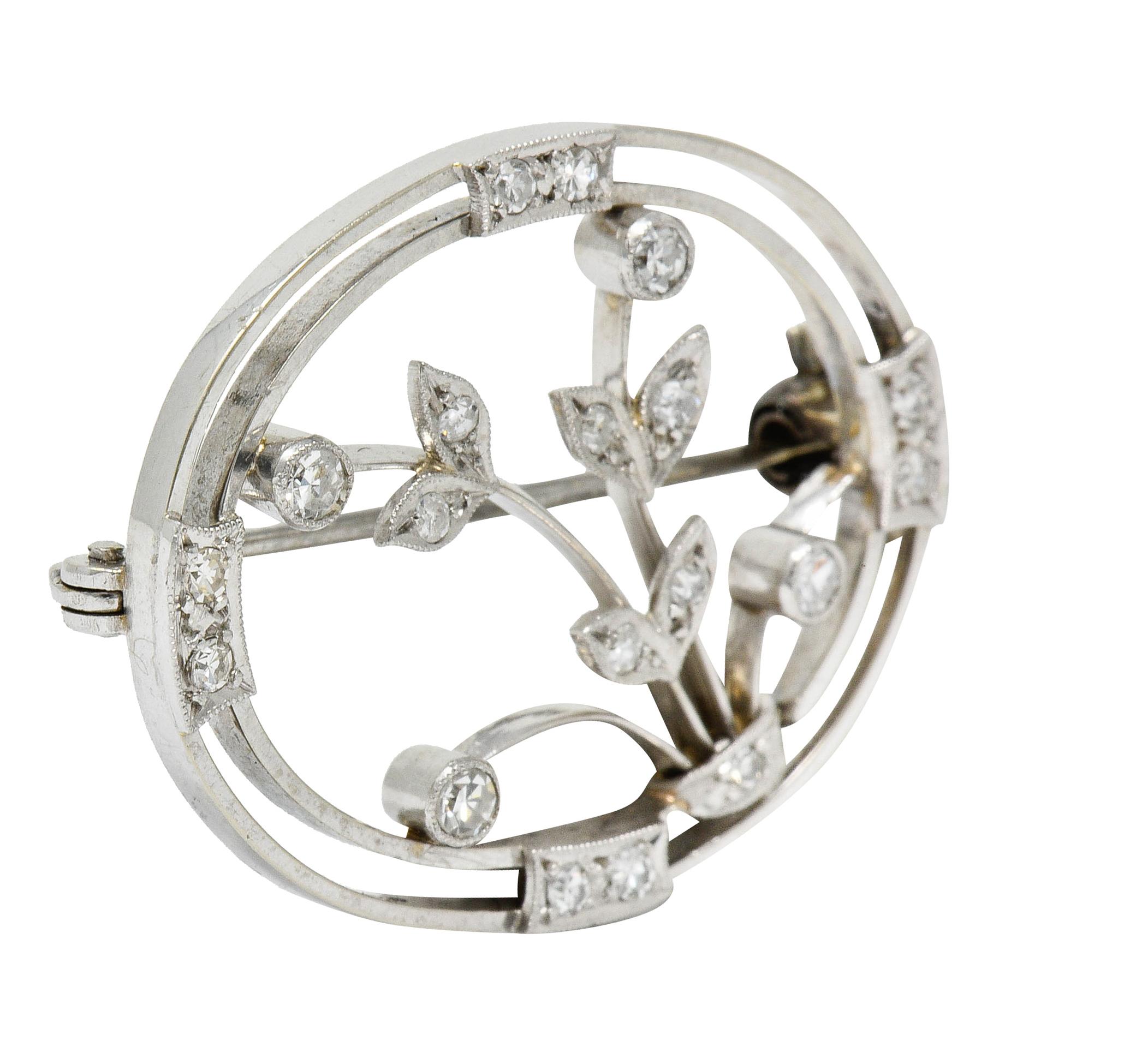 Brooch depicts a stylized platinum diamond floral arrangement

Within an 18 karat gold concentric oval frame

Single cut diamonds weigh in total approximately 0.38 carat; eye-clean and white

Stamped Plat and 18CT for platinum and 18 karat gold,