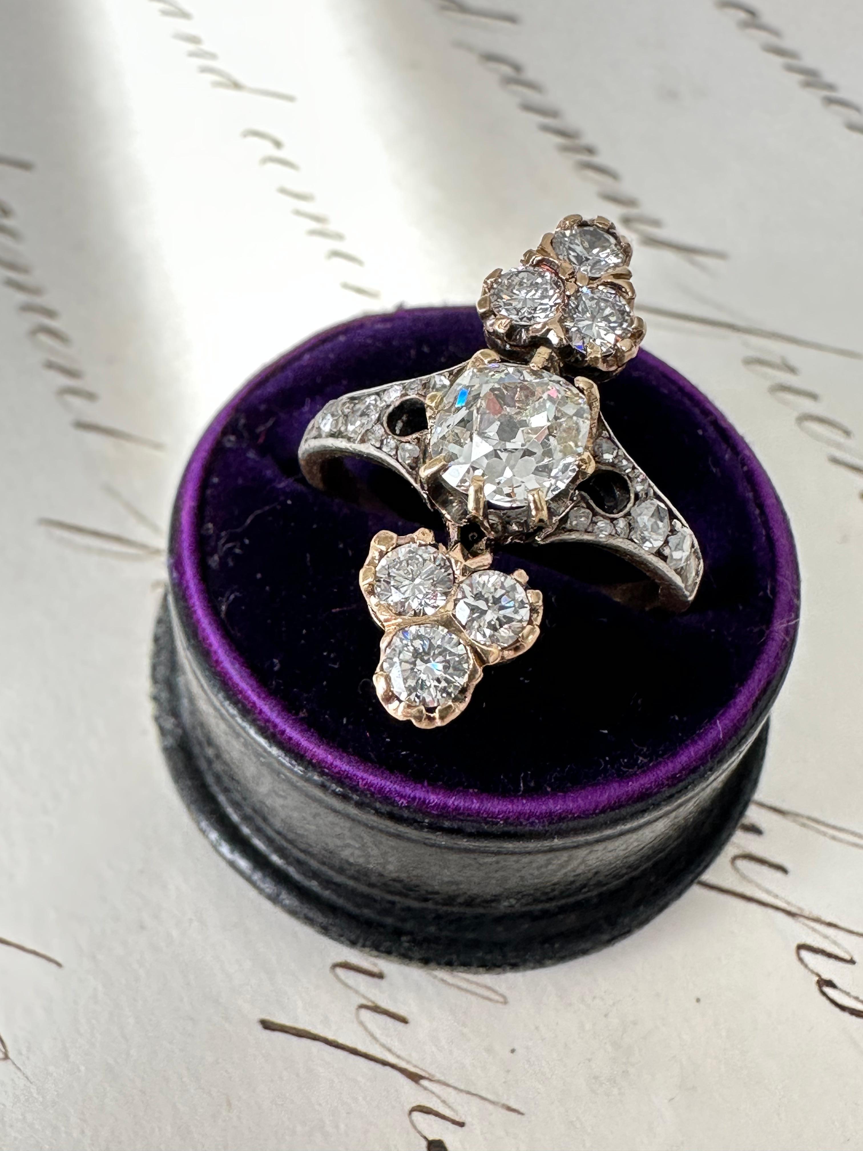 This captivating Edwardian era ring centers on a shimmering .80 carat old mine-cut diamond that displays a phenomenon called the kozibe effect. This means that when the diamond is face-up, the culet reflects in the crown facets, adding charm and