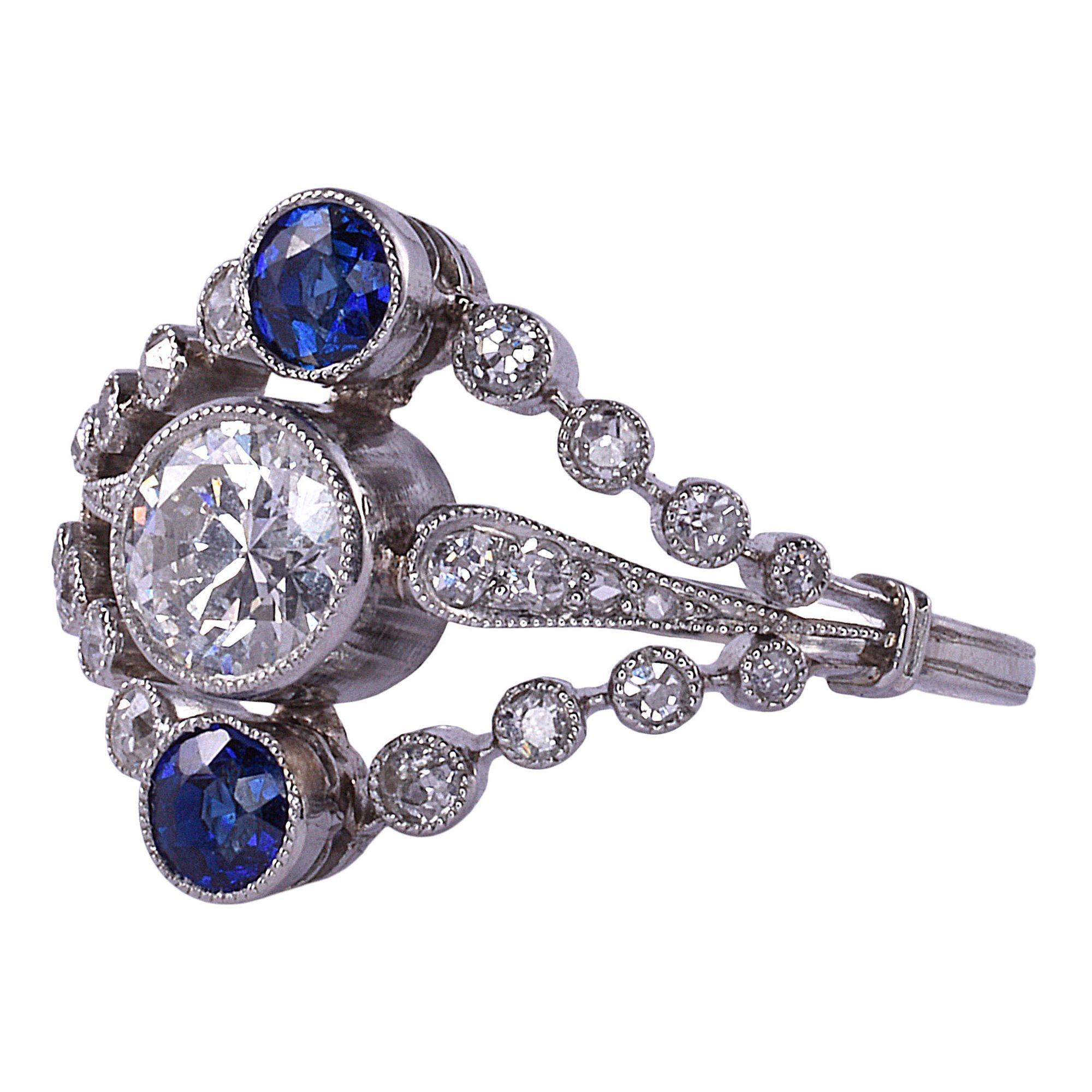 Antique French Edwardian diamond & sapphire platinum ring, circa 1910. This Edwardian ring is crafted in platinum and features a .50 carat center diamond. The center diamond has VS2 clarity and I color. There is a round sapphire above and below with