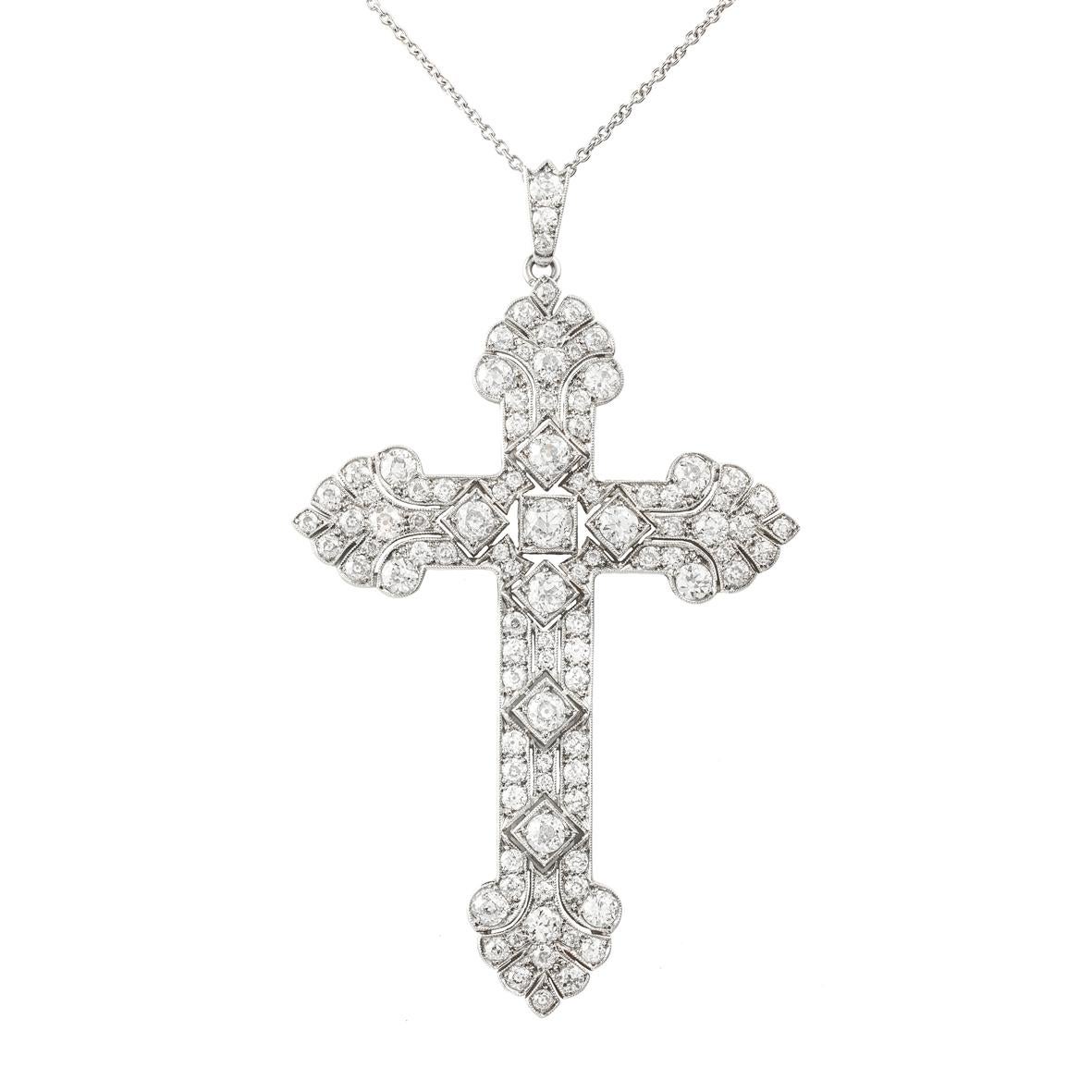 An Edwardian diamond set cross pendant, the seven principal old-cut diamonds each set in square collets to a smaller old-cut diamond set surround estimated to weigh a total of 4.2 carats, all millegrain set in openwork platinum mount with scroll