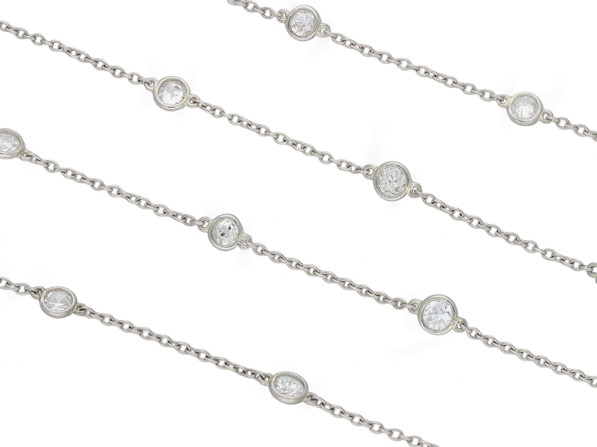 Edwardian diamond set long guard chain necklace. A platinum necklace set with fifty four round old mine diamonds in open back spectacle settings with a combined approximate weight of 7.45 carats, to an elegant long guard trace chain, composed of