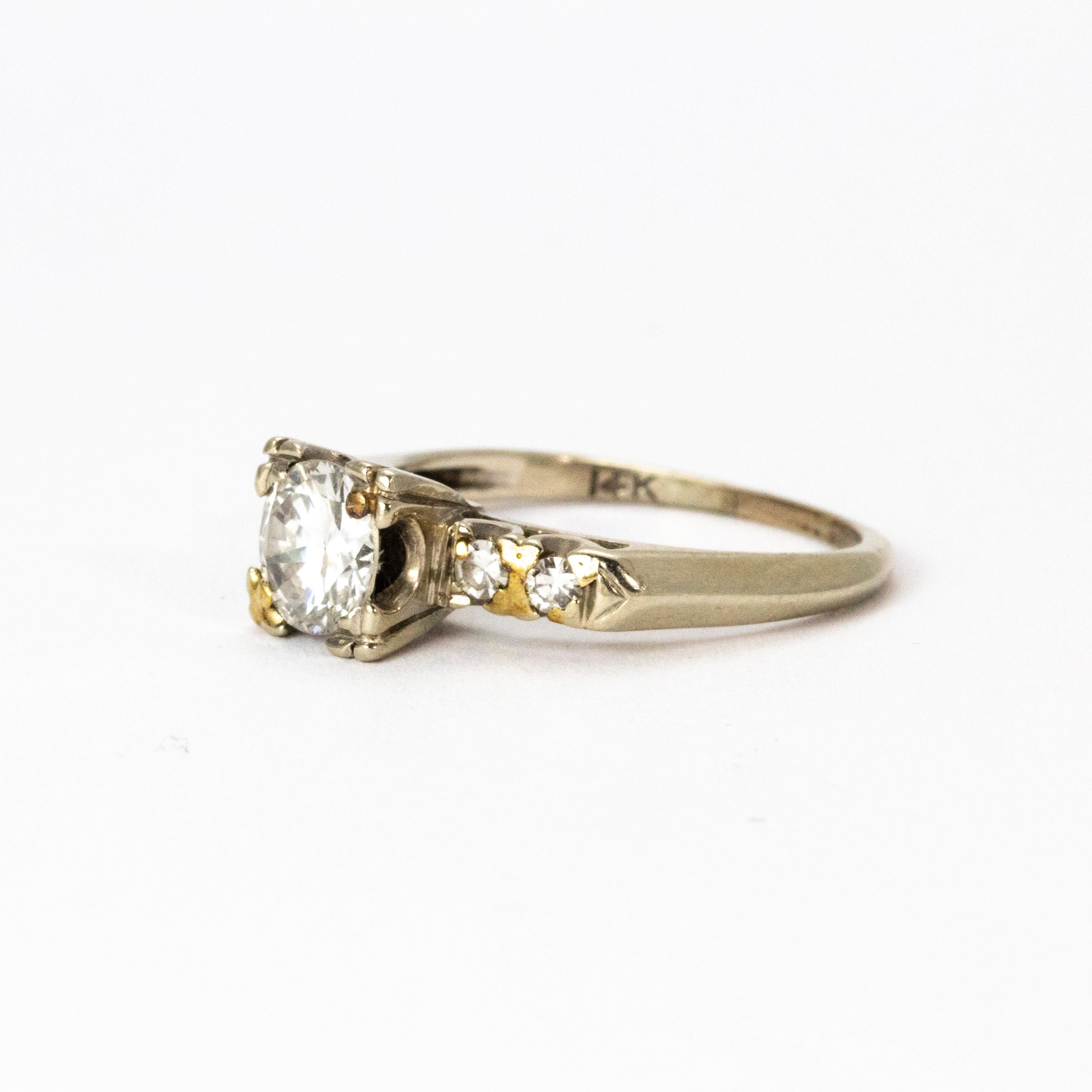 Superbe bague solitaire en diamant de l'époque édouardienne, vers 1901. Le magnifique diamant central de taille européenne ancienne mesure 80 points, est de couleur H et de pureté VS2. Les épaules sont chacune serties d'une paire de diamants, le