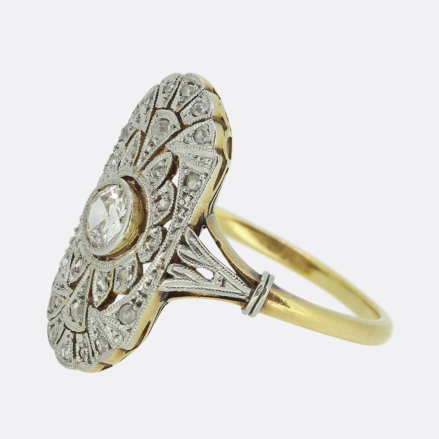 Here we have a charming diamond tablet ring taken from the early stages of the 20th century. This antique piece showcases a single round faceted old European cut diamond at the centre of the face in a fine milgrain setting. This principal stone sits