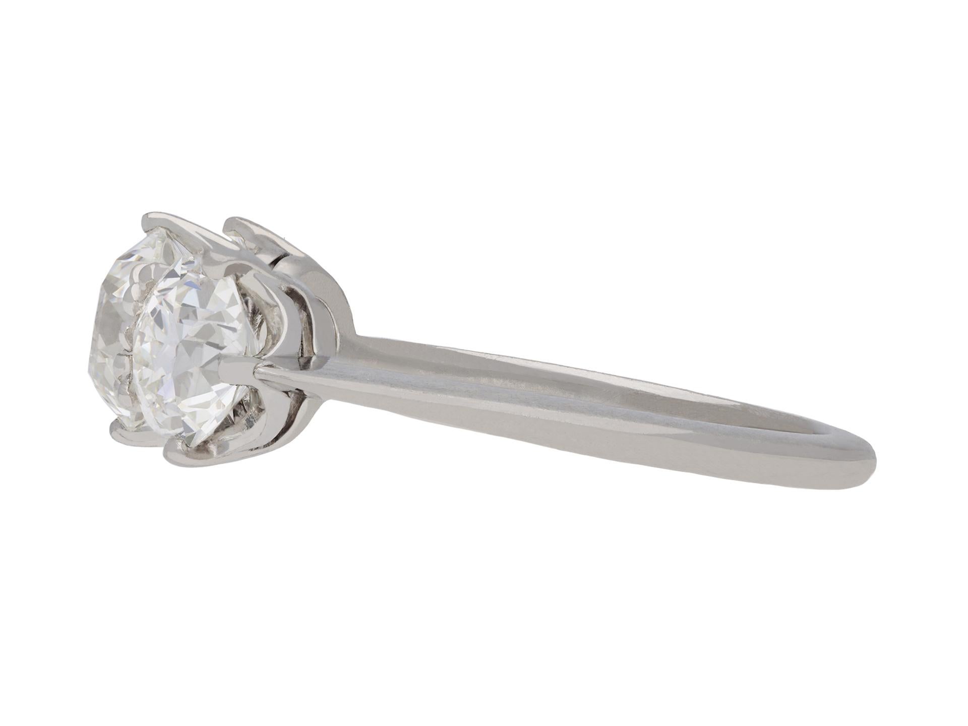 Edwardian diamond three stone ring. Set centrally with a round old cut diamond, H colour, VS1 clarity, with a weight of 1.04 carats in an open back claw setting, flanked by two round old cut diamonds, one H colour, VS1 clarity, with a weight of 0.76