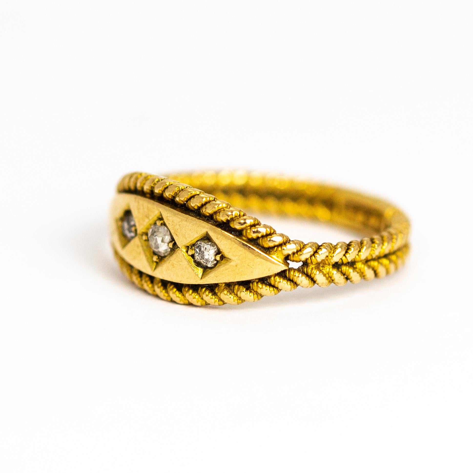 An exquisite antique Edwardian three-stone ring set with beautiful graduated old European cut diamonds in square settings. The stunning band of this ring resemble a pair of twisted ropes which part around the face and stones. Modelled in 18 karat