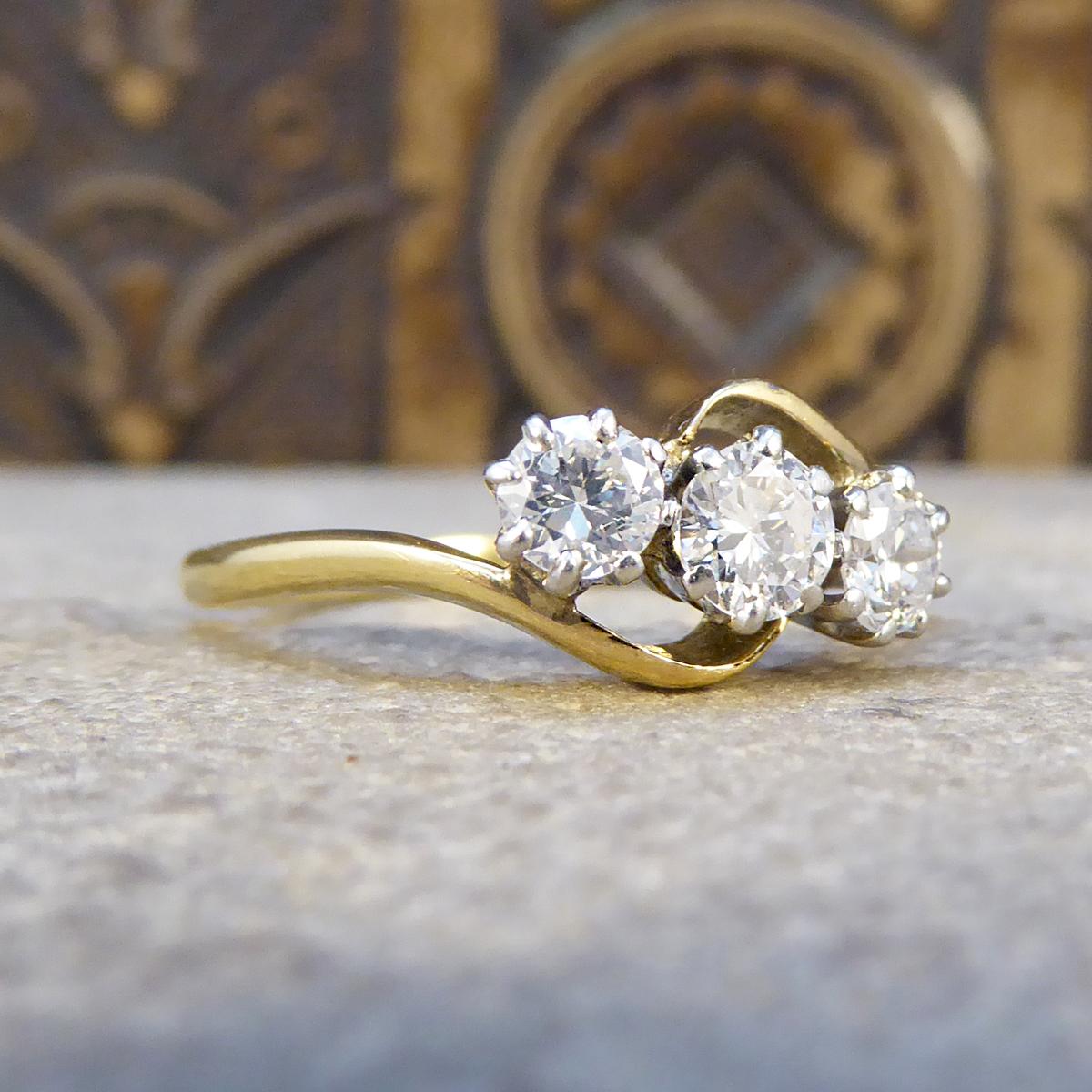 A very elegant three stone diamond ring that is set with three sparkling diamonds. The band is 18ct Yellow Gold with a 18ct White Gold setting on the top. A very pretty antique ring hand crafted in the Edwardian era.

Diamond Details:
Cut: Round