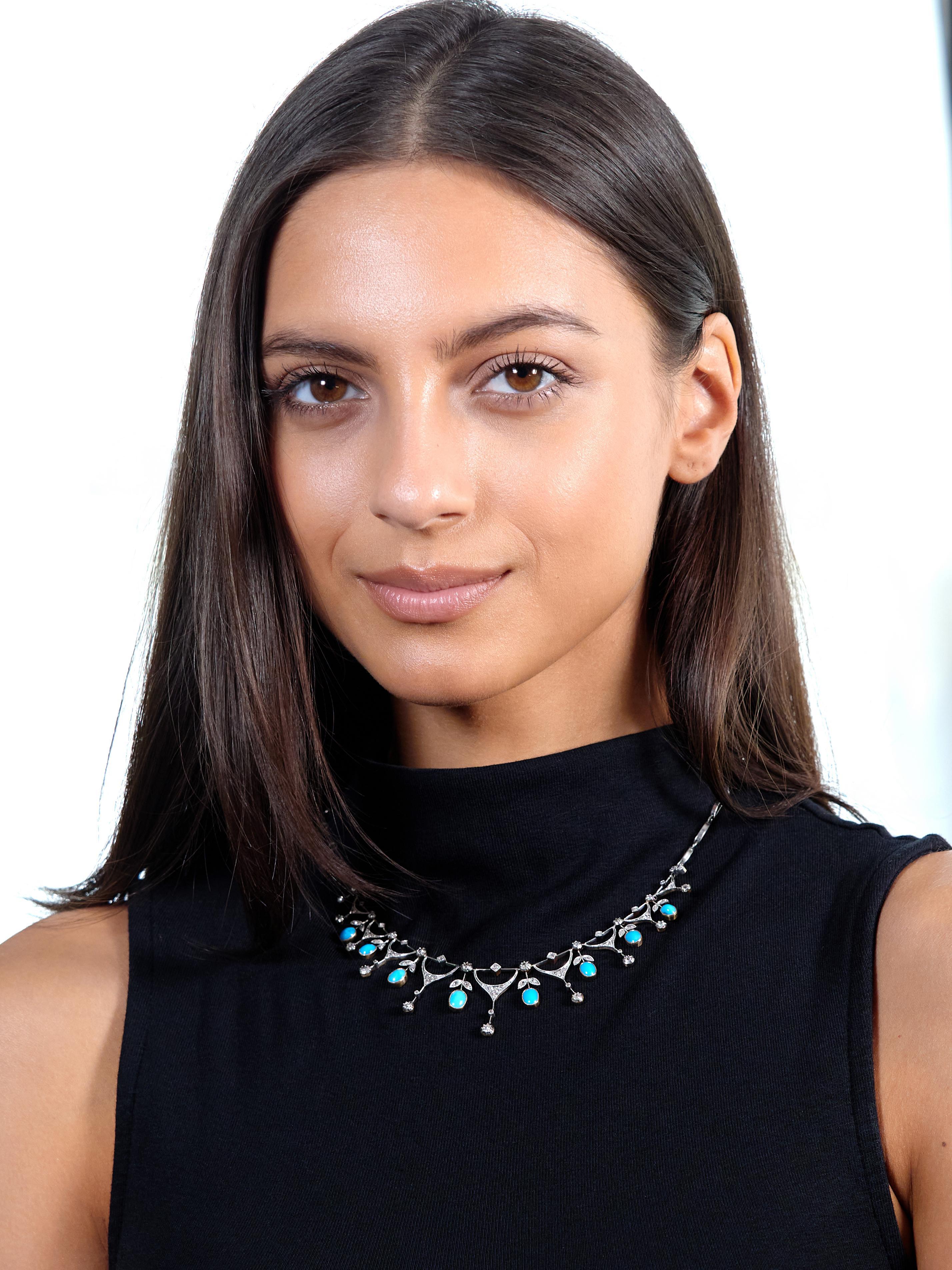 Comprised of fancy arching platinum links connected via jump rings and centering a fringe station
Comprised of graduating draped garland motif links alternating with foliate motif links
Suspending oval shaped cabochon fringe set in gold milgrain