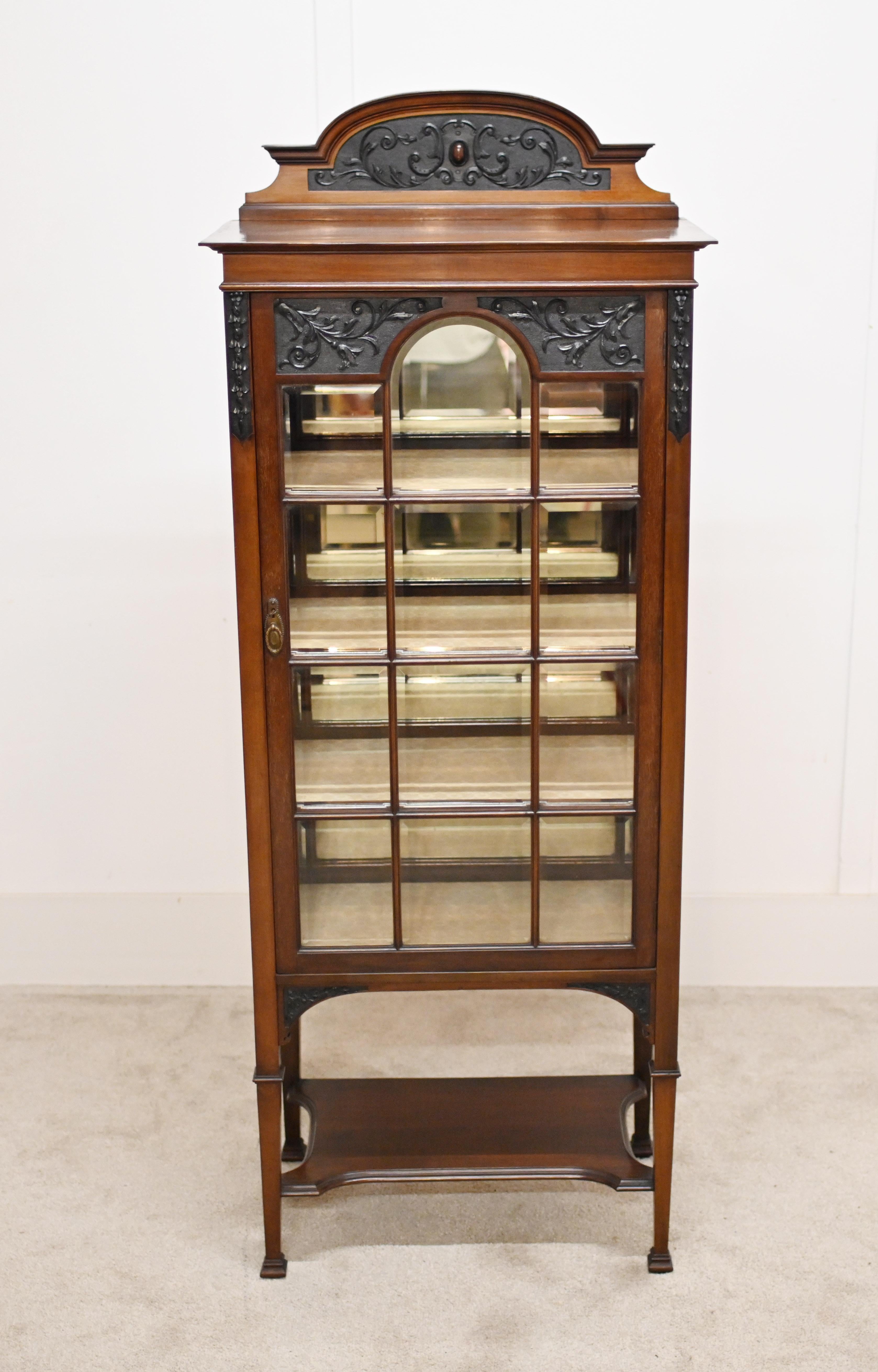 Edwardian display cabinet in mahogany with finely carved decoration
The carved decoration in black very intricate and features art nouveau motifs and floral sprays
Also features a glass insert to the centre
The doors contain bevelled glass panels