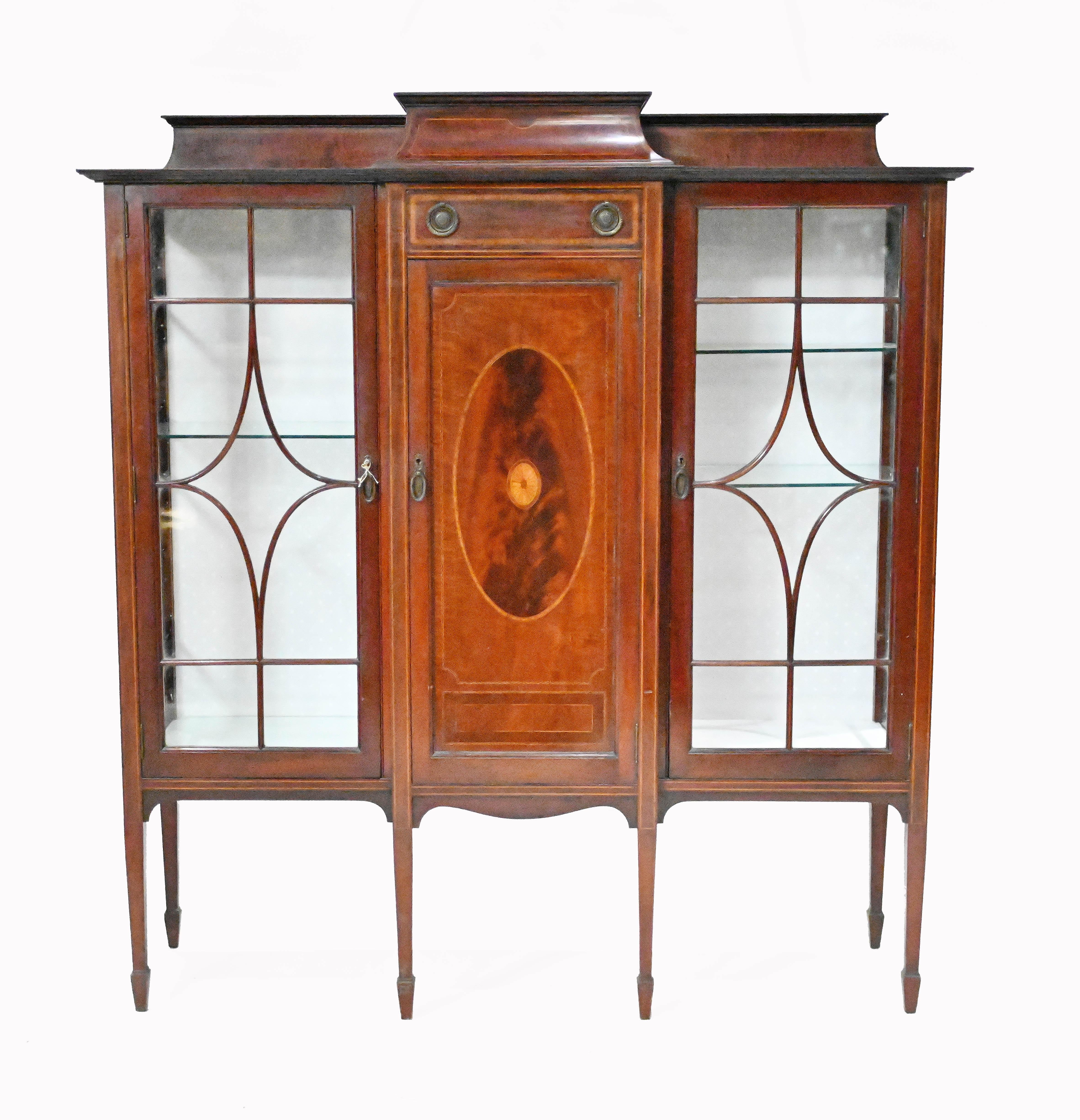 Gorgeous Edwardian display cabinet in the Sheraton manner
We date this to circa 1910 and it's crafted from mahogany with marquetry inlay work
Inlay motifs include shell motifs and satinwood crossbanding
Glass doors open out and feature astragal