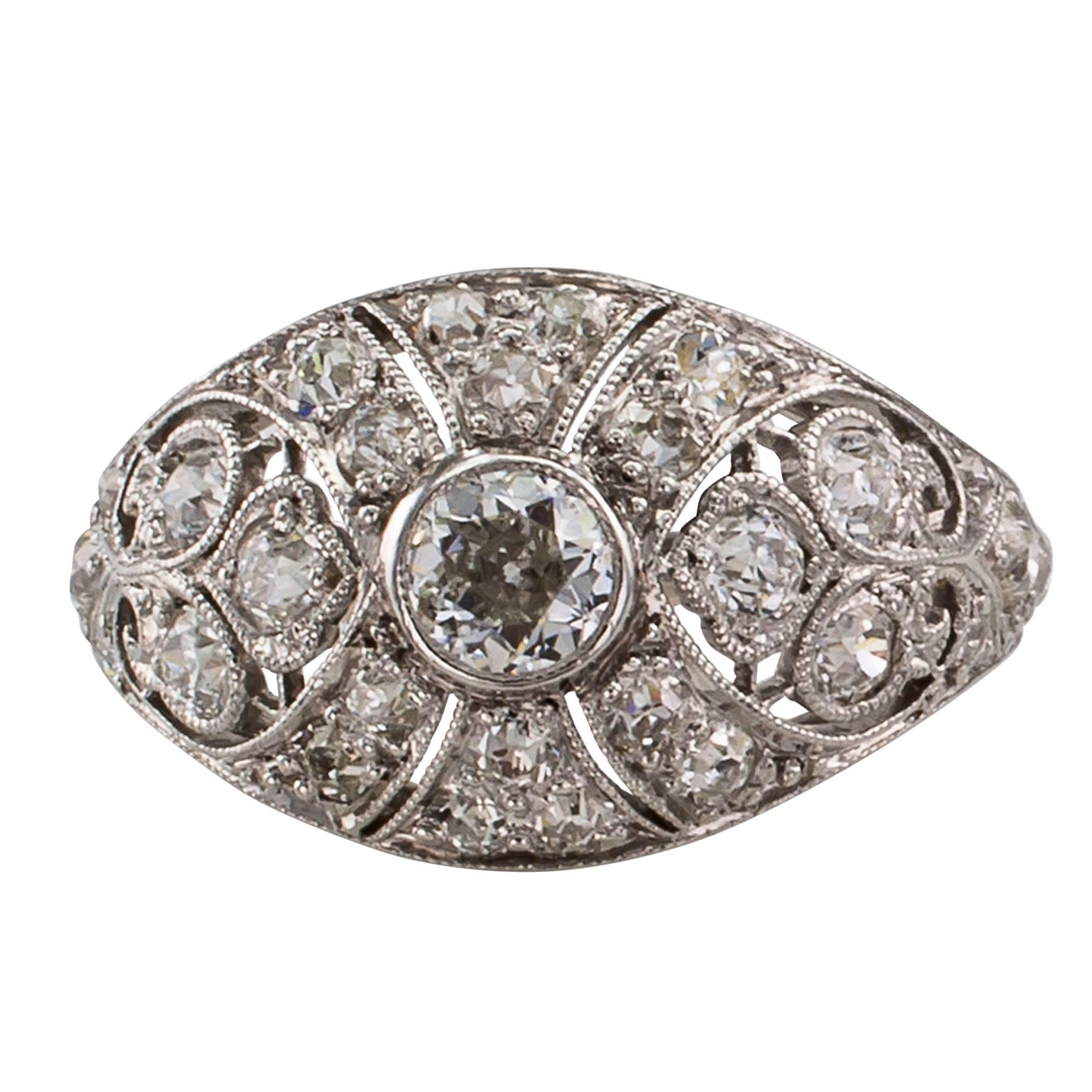 Edwardian 1910 diamond and platinum domed ring. The design centers upon a bezel-set old European-cut diamond on a platinum mounting set throughout with smaller round diamonds, the twenty-nine diamonds together totaling approximately 1.00 carat,