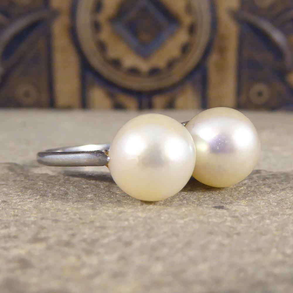 This delightful ring hold two lustrous, rose-white cultured pearls, shimmering side by side in this gorgeous Platinum ring. The two pearls are sat in a setting decorated in parallel lines just adding to the class of this ring. Hand crafted in the