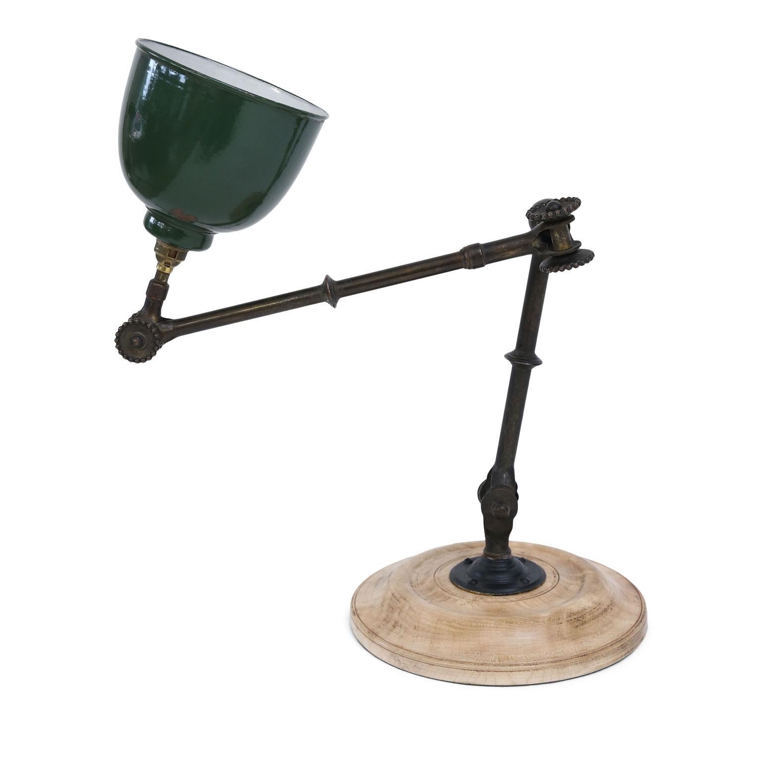 Large-scale Edwardian draftsman lamp (circa 1900-1915) of English origin that is almost industrial in style. Its articulated arm features adjustable knuckle joints and an original green enameled shade. Stands upon its original turned sycamore base.
