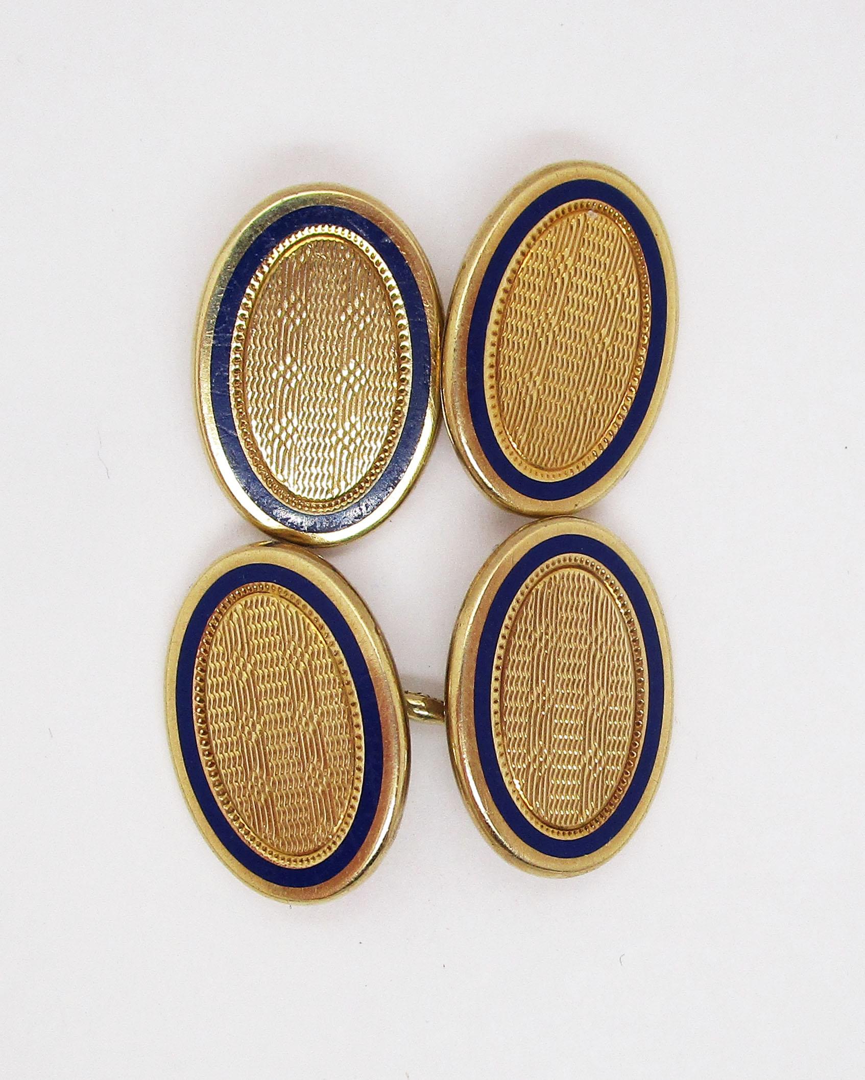 These excellent cufflinks by Durand & Co. are Edwardian and feature a fantastic combination of bright 14k yellow gold and royal blue enamel borders. The panels have a classic oval shape with a bold edge. The outside border is bright 14k gold,
