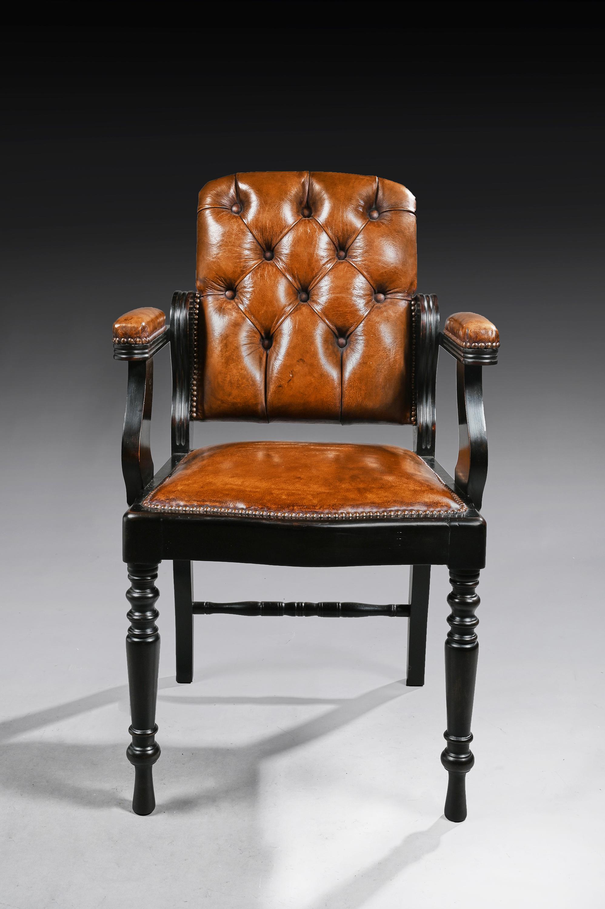 A Edwardian ebonized and leather buttoned barbers armchair / desk chair.

English, circa 1910.

This well designed chair, originally used as a barbers chair with an adjustable back, now has a fixed back so to be used as an armchair - desk chair.