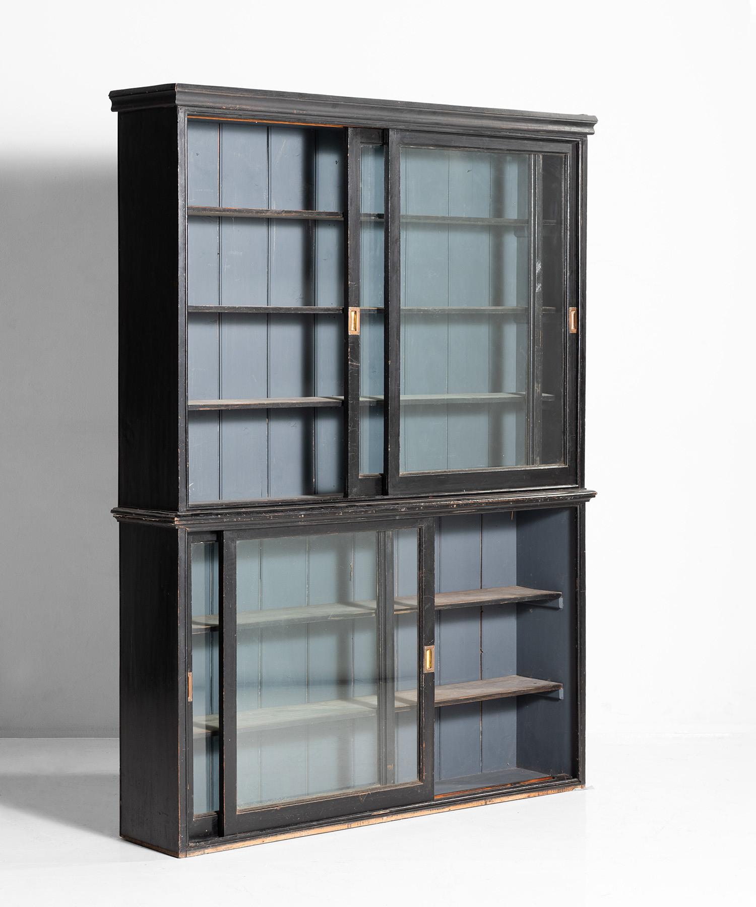 Bookcase with sliding doors and original brass handles in period painted finish.

 