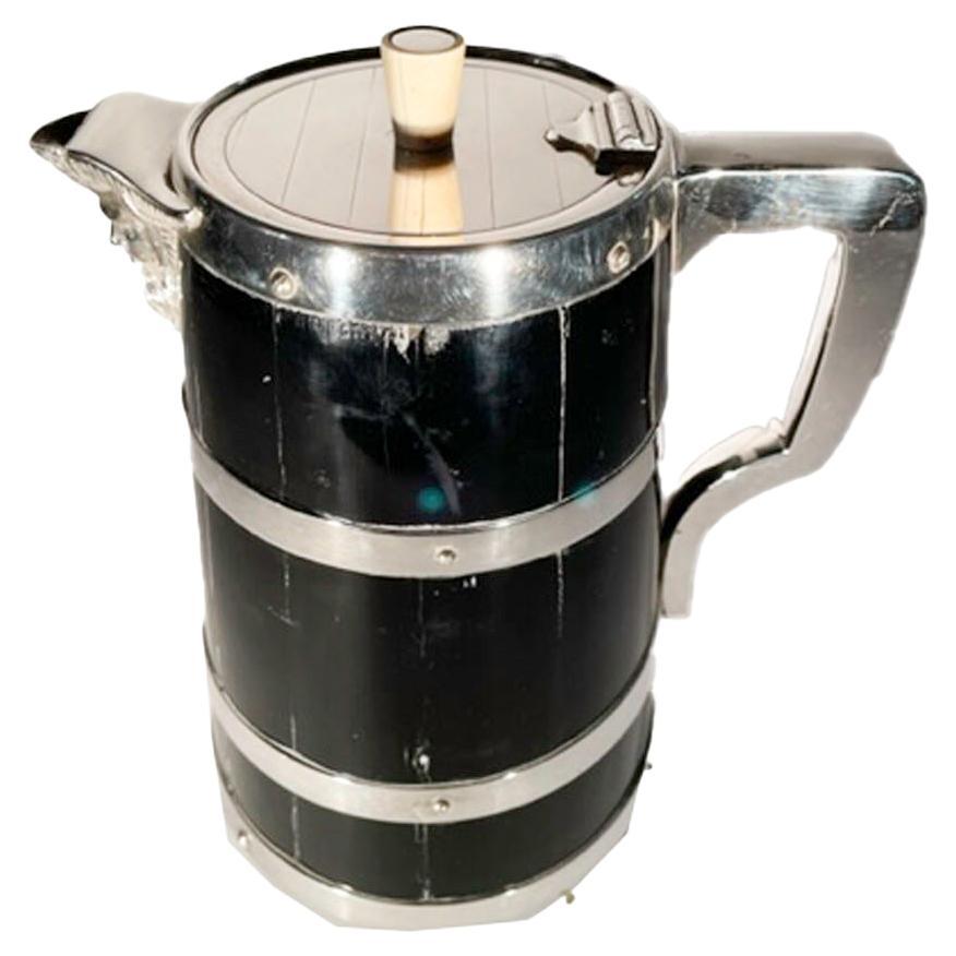 Edwardian silver plate mounted ebonized pitcher with an ironstone liner. The staved wood pitcher with silver plate handle, bands, hinged lid and Bacchus mask spout.