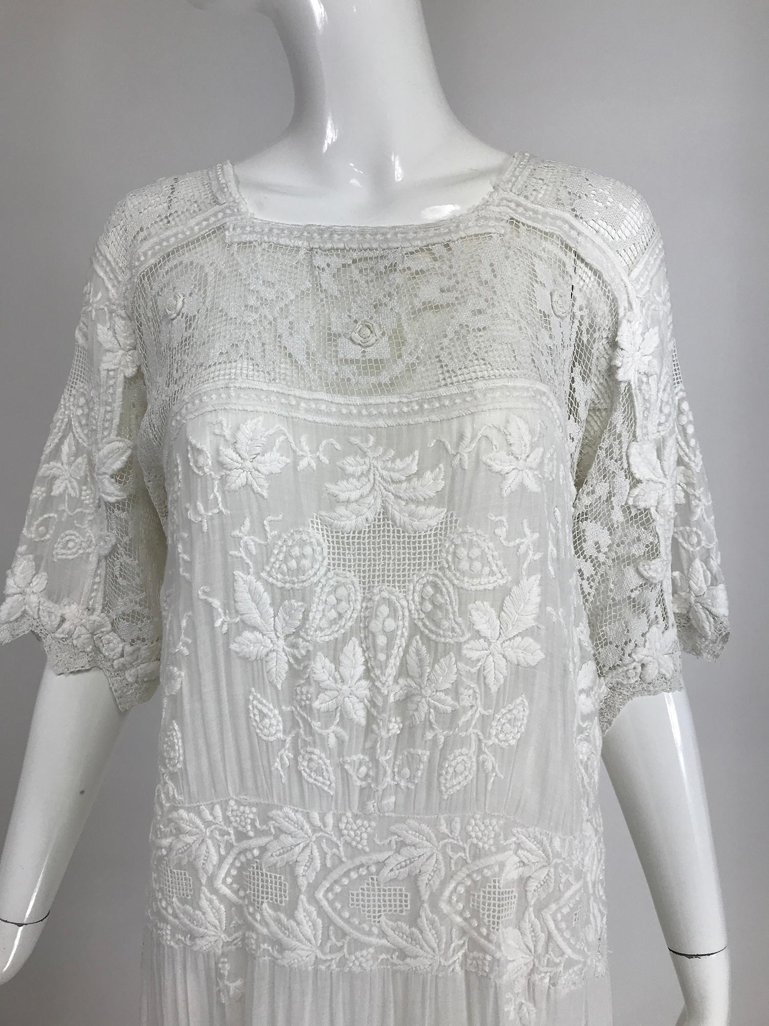
Edwardian handmade embroidered & appliqued, white batiste and filet lace dress. Heavily embroidered fine cotton batiste tea dress from the early 1900s in a style that is very wearable today. A combination of batiste, a fine translucent cotton,