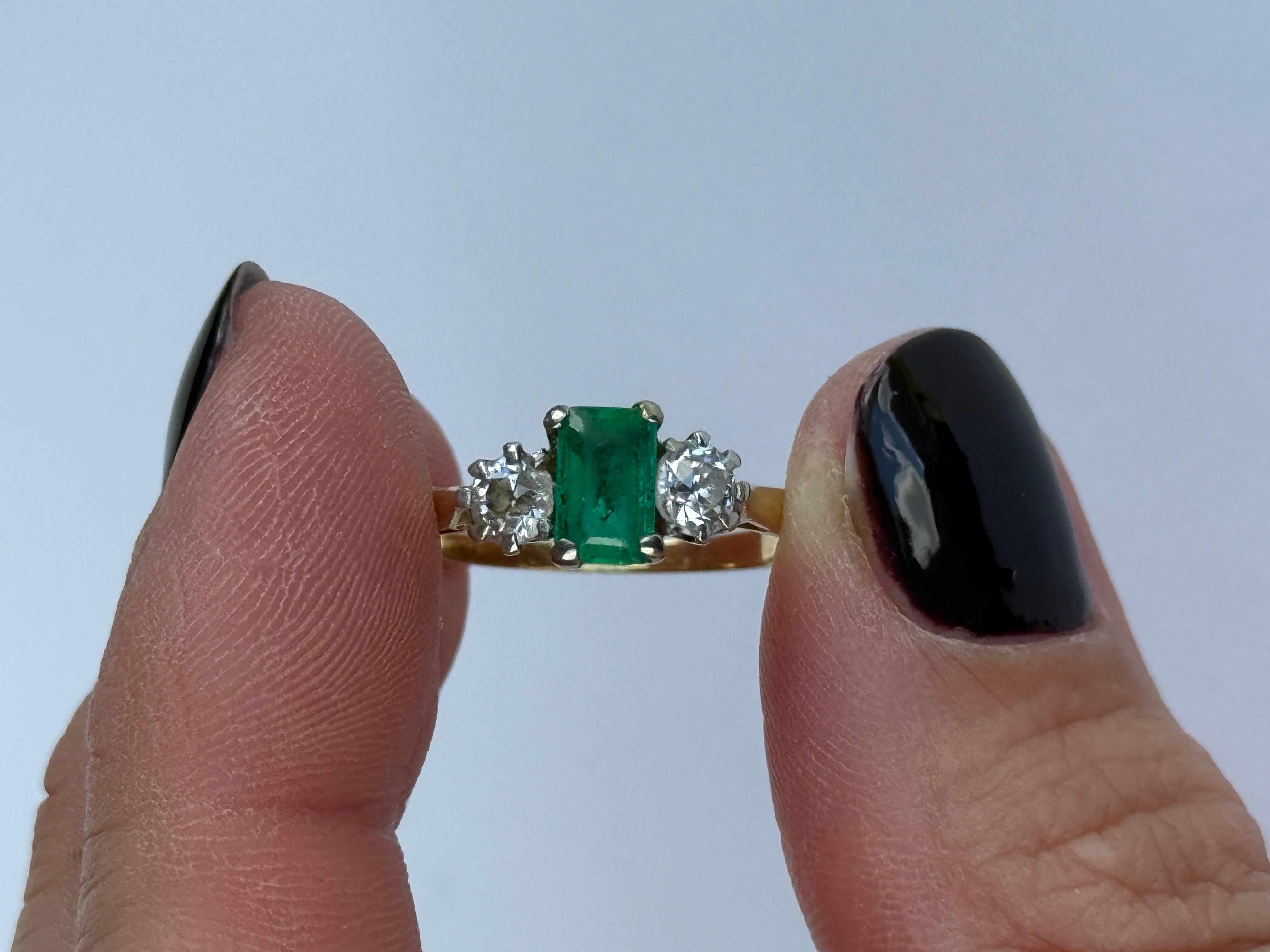Der zentrale Smaragd ist so hell und schön und misst ca. 50pts. Auf beiden Seiten befinden sich zwei hell schimmernde Diamanten von je ca. 20 pt. Der Ring ist aus 18-karätigem Gold modelliert und die Steine sind in Platin gefasst.

Ringgröße: O 1/2