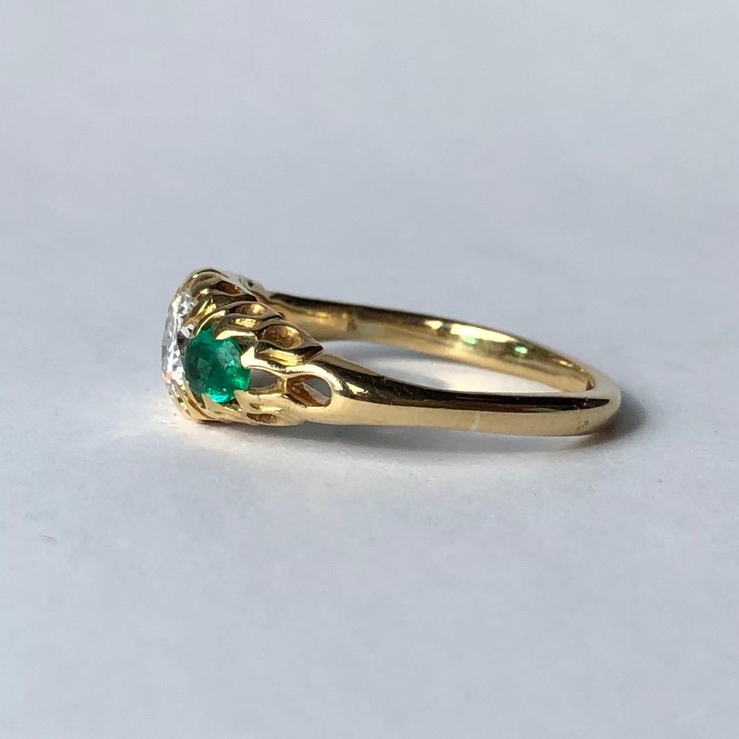 This gorgeous ring holds a. old European cut diamond at the centre measuring 50pts which is bright and the most wonderful sparkle. Either side of the stone are bright green pear shaped emeralds. These stones are slightly worn with age but this