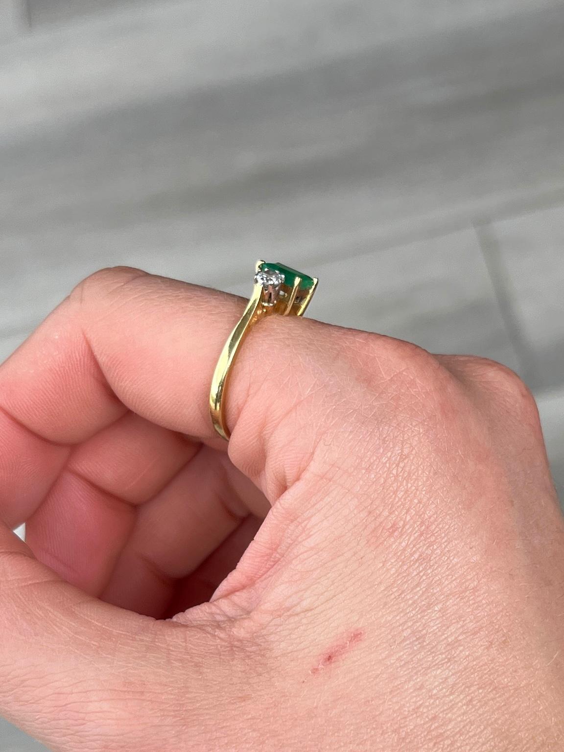 The central emerald is so bright and beautiful and measures 30pts. Sat either side it are two bright shimmering old European cut diamonds each measuring 20pts. The ring is modelled in 18ct gold.

Ring Size: N or 6 3/4 
Height Off Finger: