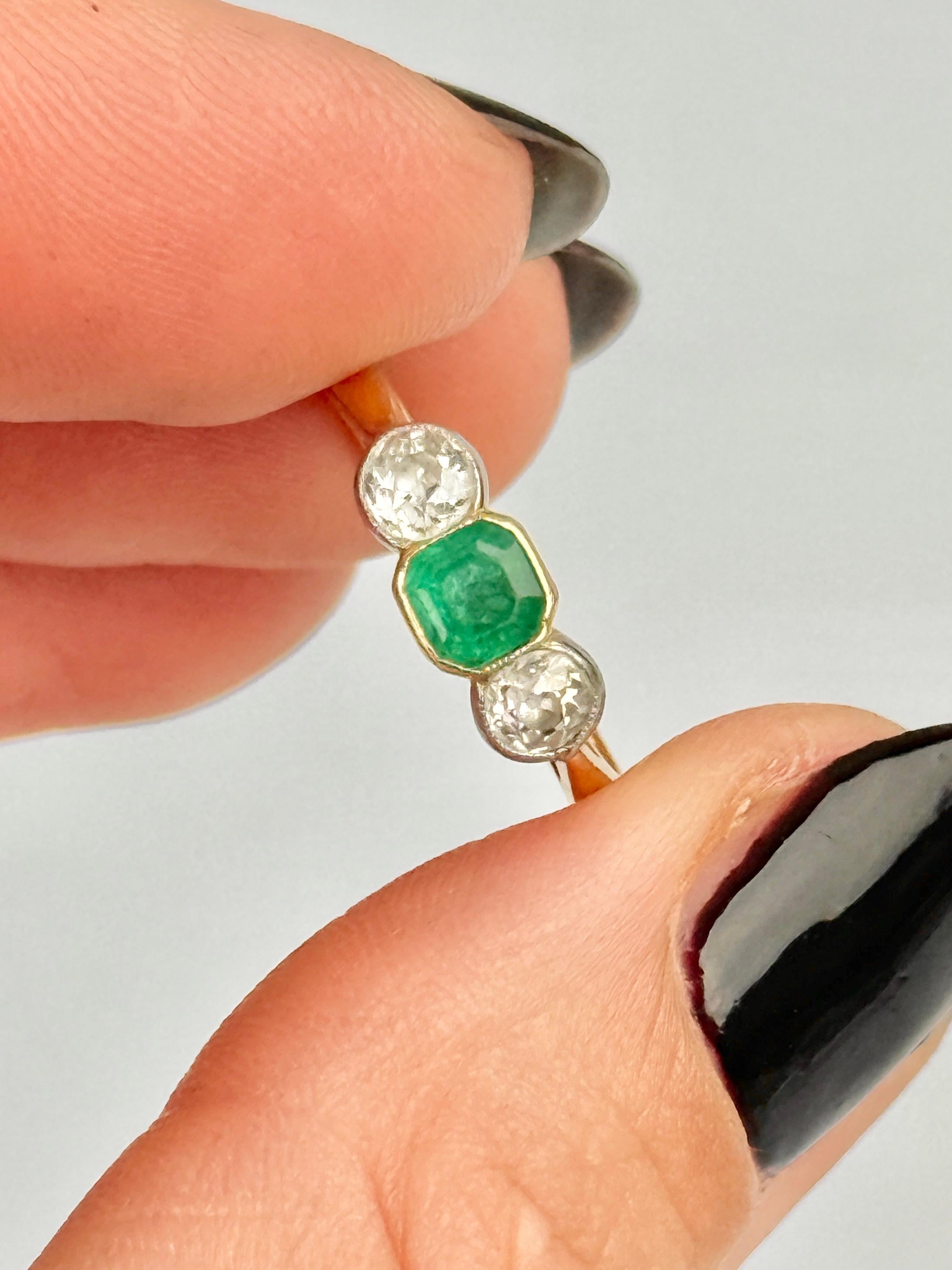 Lo smeraldo centrale è così luminoso e bello e misura circa 40pt. Ai suoi lati si trovano due brillanti diamanti taglio old mine che misurano circa 20pt ciascuno. L'anello è realizzato in oro 18ct e le pietre sono incastonate in platino.

Misura