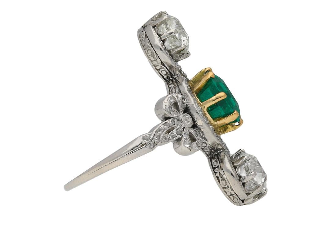 Edwardian emerald and diamond crossover ring. Set to centre with a single square emerald-cut natural Colombian emerald with no colour enhancement and minor clarity enhancement in an open back claw setting with an approximate weight of 2.50 carats,