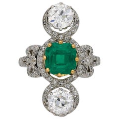 Anillo eduardiano cruzado de esmeraldas y diamantes, circa 1915