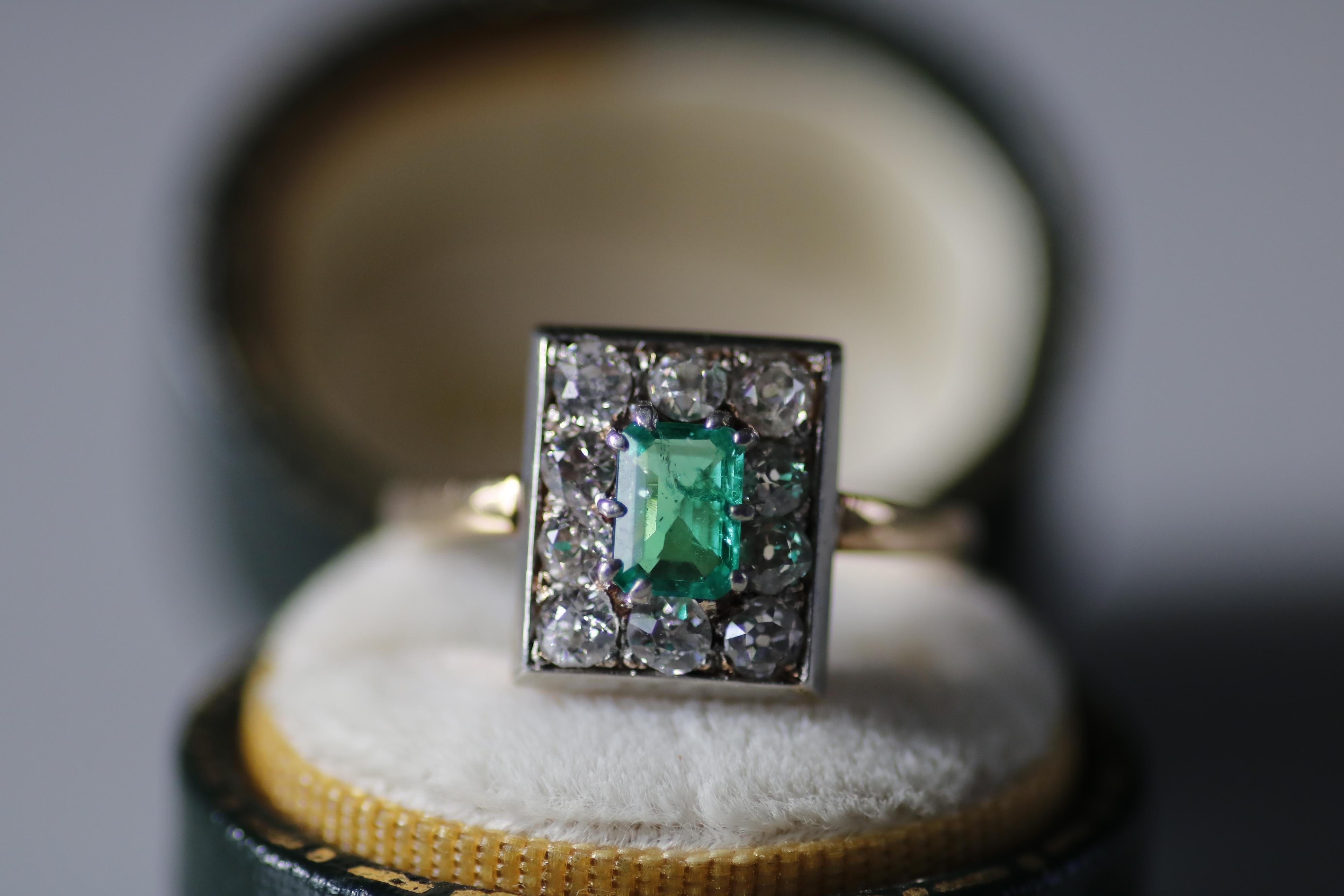 Dieser elegante Ring aus 14-karätigem Gelbgold und Platin präsentiert in seiner Mitte einen leuchtenden 5,77 x 4,18 mm großen Smaragd von etwa 0,39 Karat. Um diesen lebhaften Edelstein herum sind zehn Diamanten im alten europäischen Schliff von