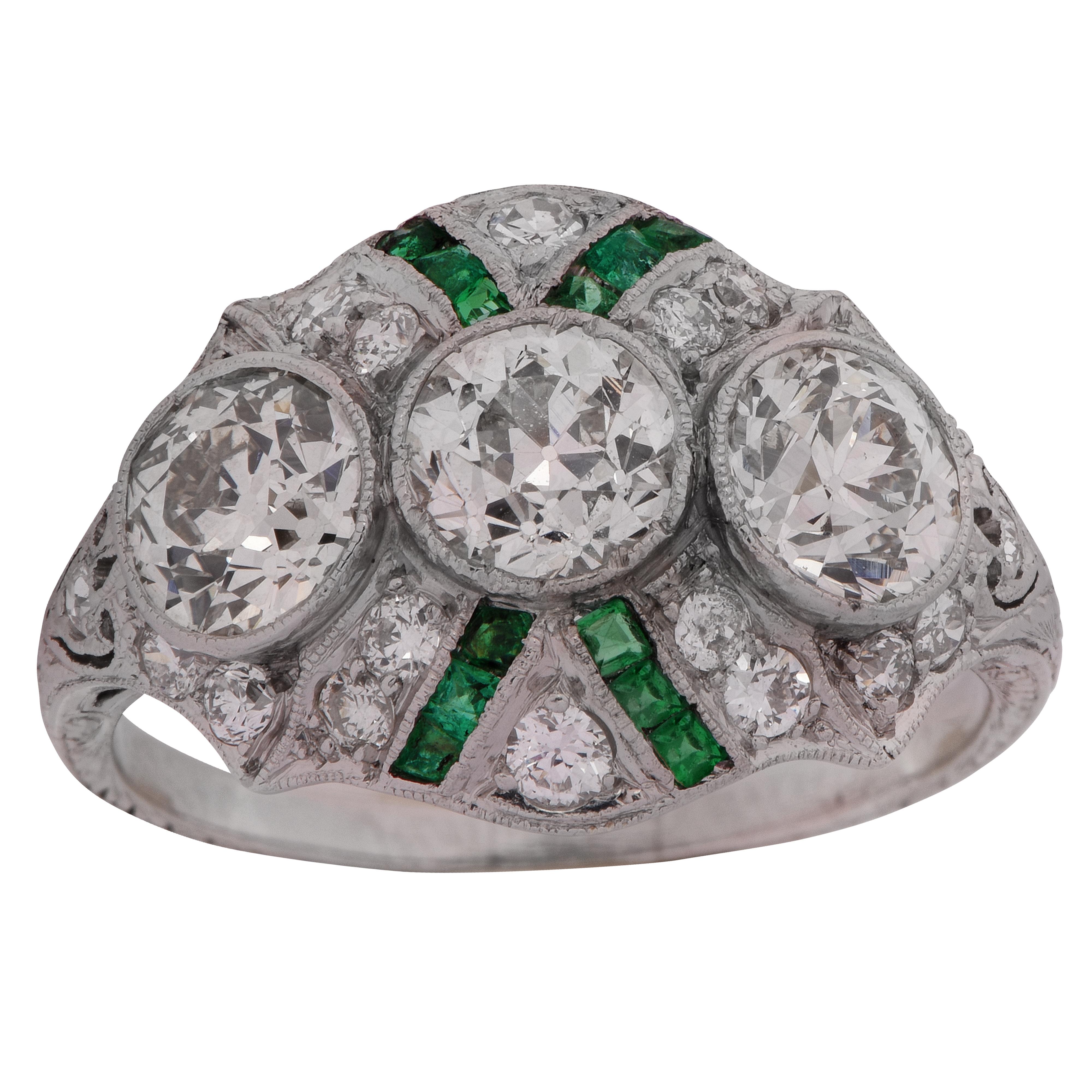 Stunning Edwardian ring, finely crafted in Platinum, showcasing 3 gorgeous European cut diamonds I-J color, VS clarity, weighing approximately 2.20 carats total, framed in milgrain, and accented by .50 carats of single cut and European cut diamonds.
