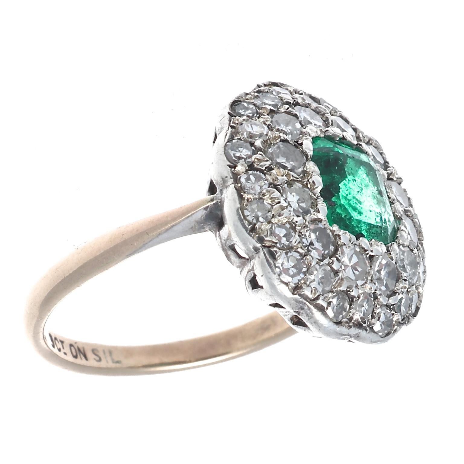 Stunning beauty is depicted through colorful delicate design.  Featuring a deep forest green Colombian emerald surrounded by old cut diamond halos. Designed in 18k yellow and white gold. Ring size 5-3/4 and can easily be resized to fit, if needed